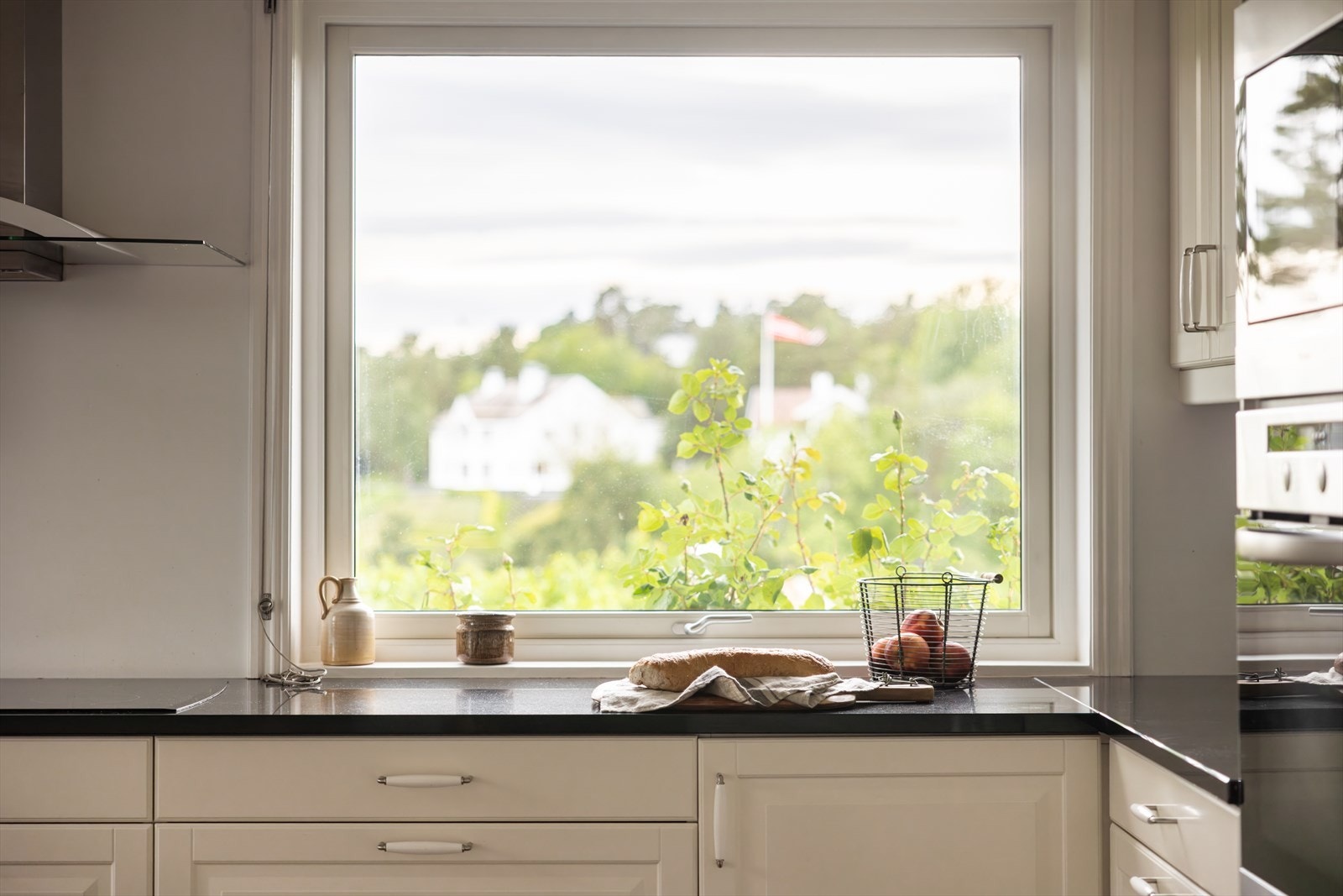 Store vindusflater gir rikelig med naturlig lys og nydelig utsyn mot grøntområder og nabolaget. Galleribilde