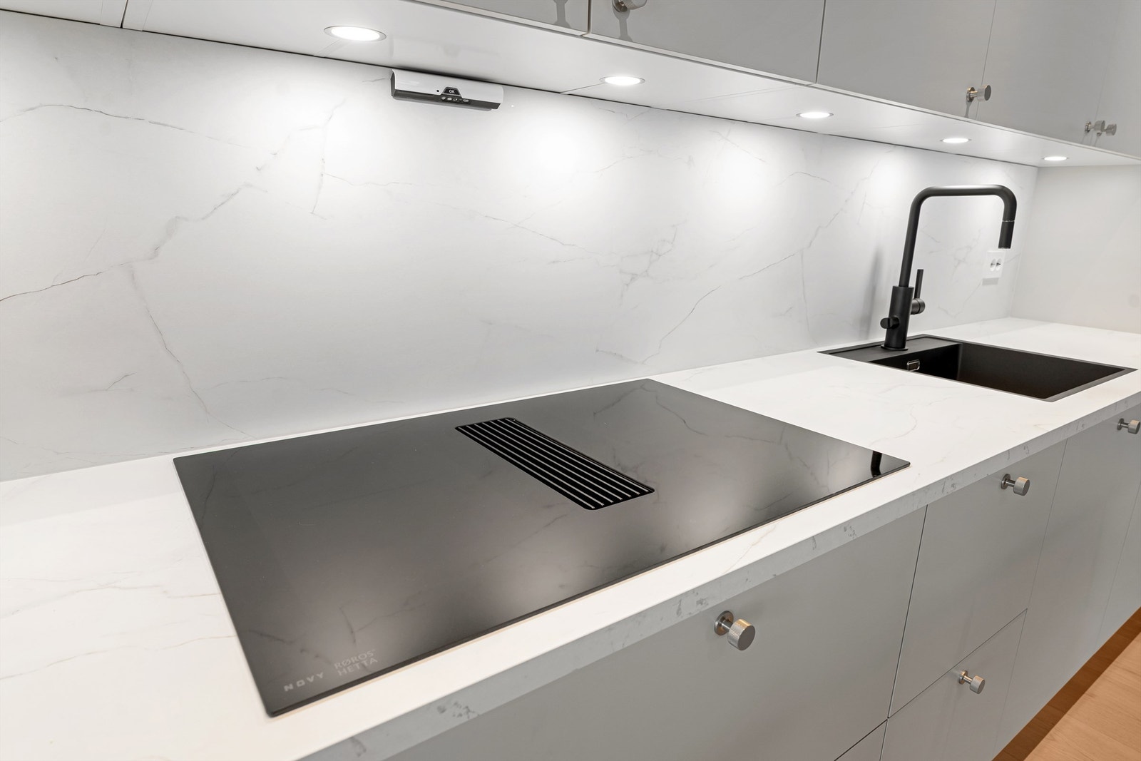 Svarte stilrene detaljer i vask, servant og induksjonstopp av topp kvalitet fra Røroshetta med innebygd vifte Galleribilde