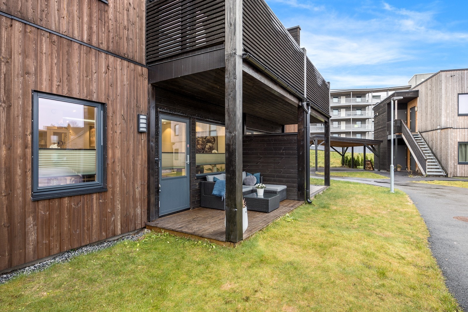 Markterrassen har dekke i tre, og det er satt opp en høy, tett levegg mot naboen Galleribilde