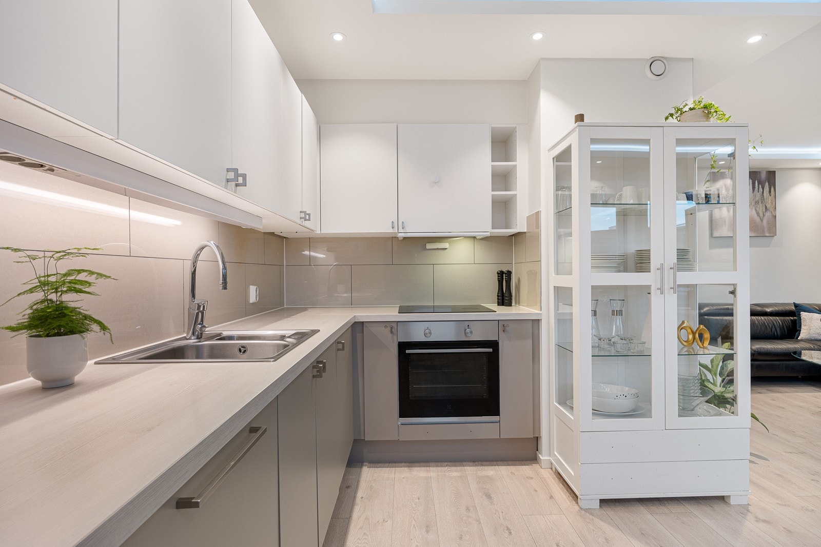 Innredningen fra Sigdal har hvite og grå fronter og hvit laminatbenkeplate med nedfelt kum i stål Galleribilde