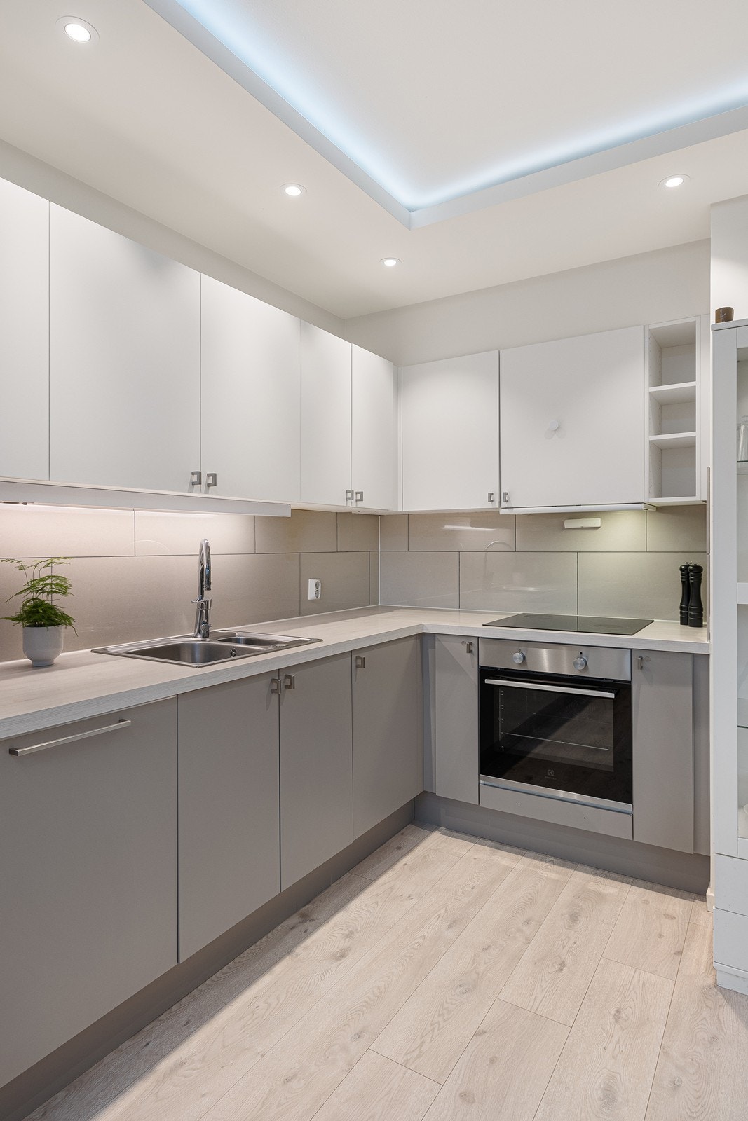 Kjøkkenet er utstyrt med integrerte hvitevarer som oppvaskmaskin, kjøl-/fryseskap, stekeovn og induksjonstopp, samt ventilator, komfyrvakt og god arbeidsbelysning Galleribilde