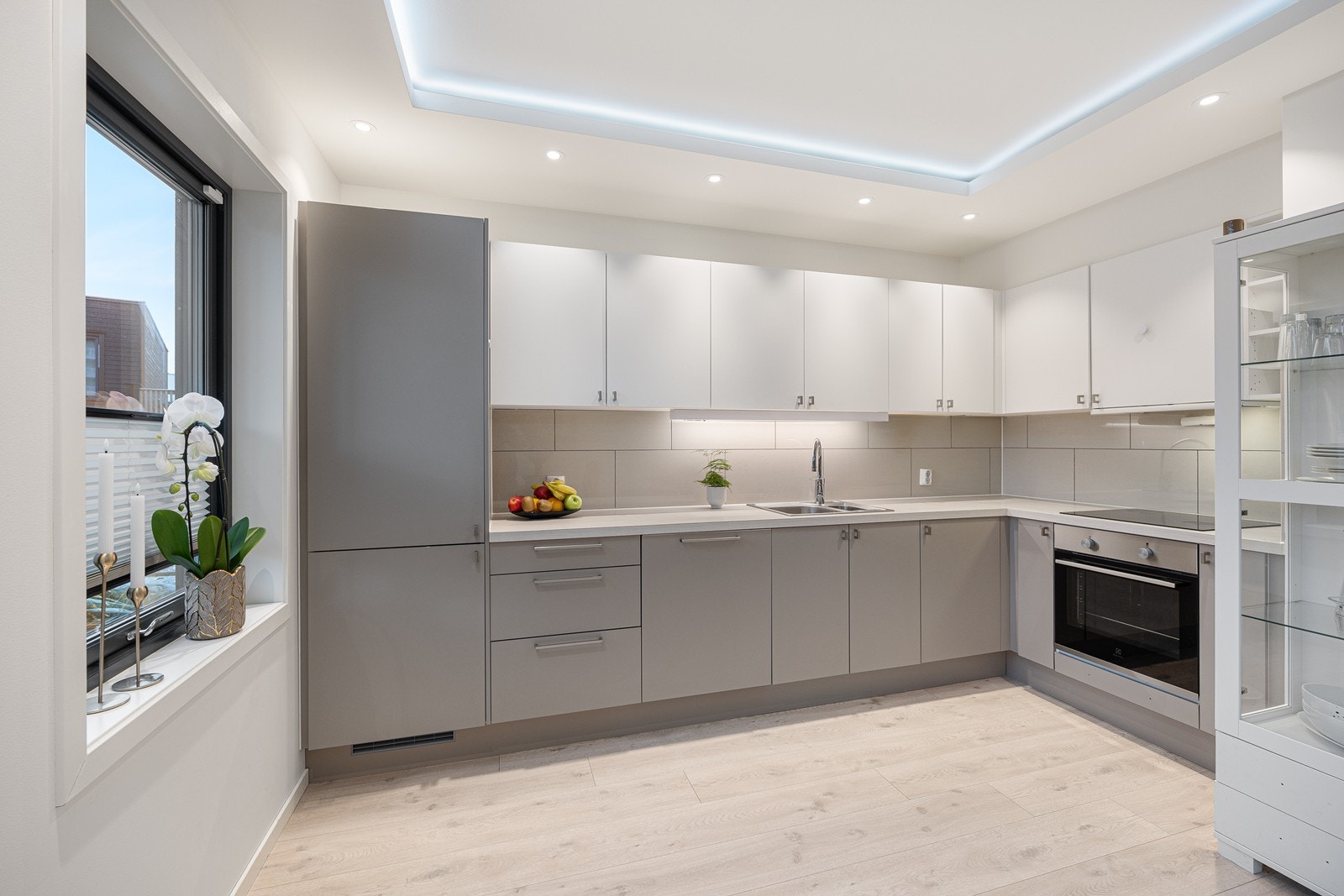 Kjøkkenet har et stilrent og pent design med gode benkeflater, rene linjer og rikelig med oppbevaringsplass Galleribilde