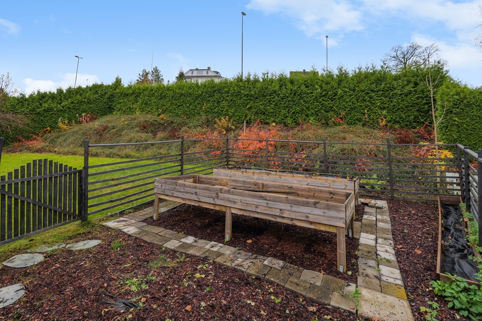 Mot nordvest er det anlagt inngjerdet urtehage med store plantekasser. Det er plantet jordbær i den ene kassa. Galleribilde