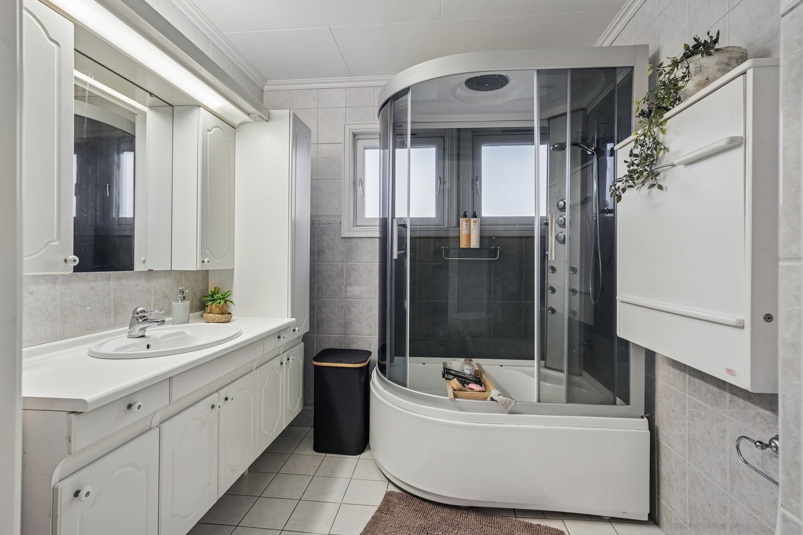 Eldre, men stort og funksjonelt bad med nyere steamdusj, wc og romslig servantskap. Galleribilde