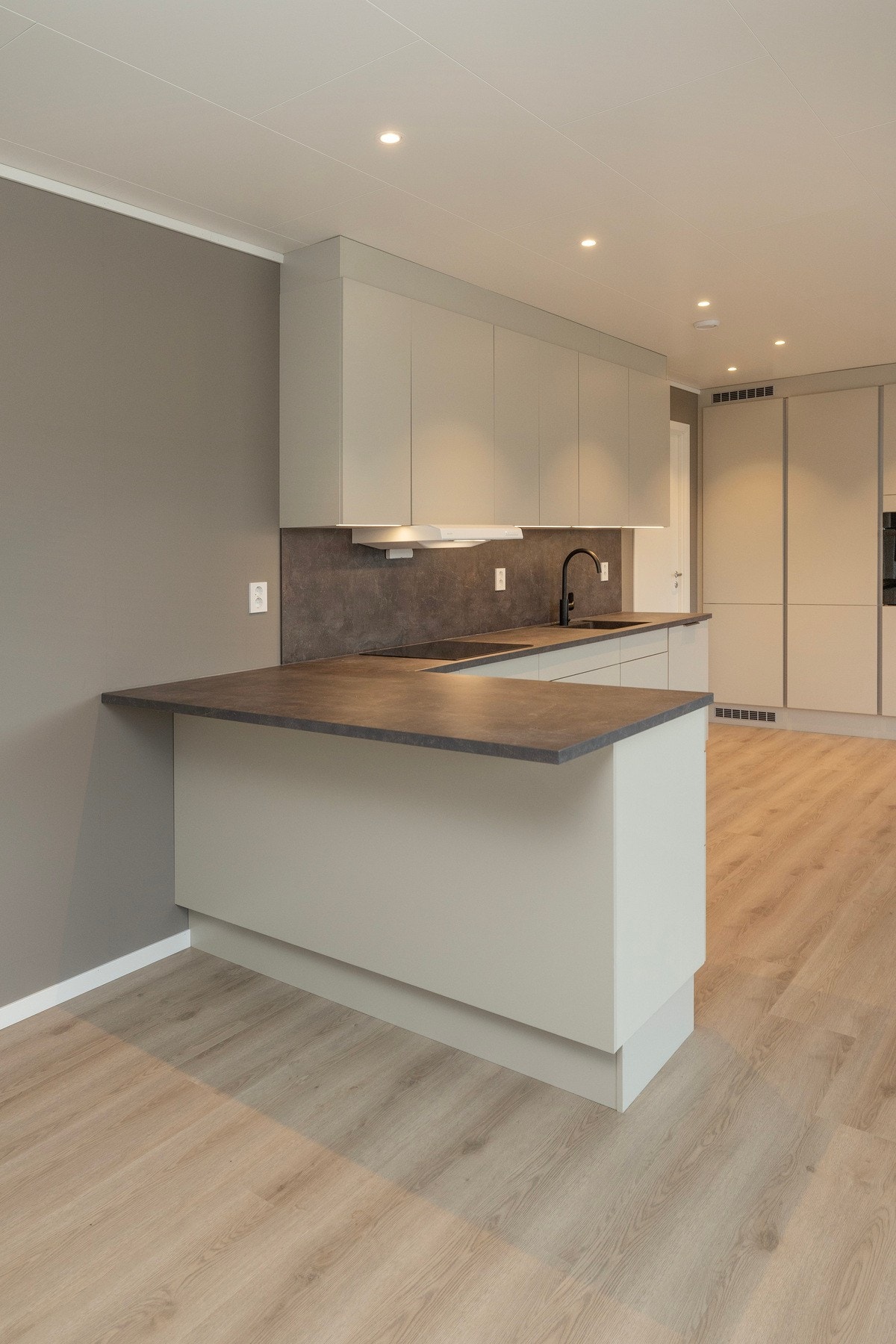 Kjøkkenbenken har en utstikker med stor kjøkkenplate. Galleribilde