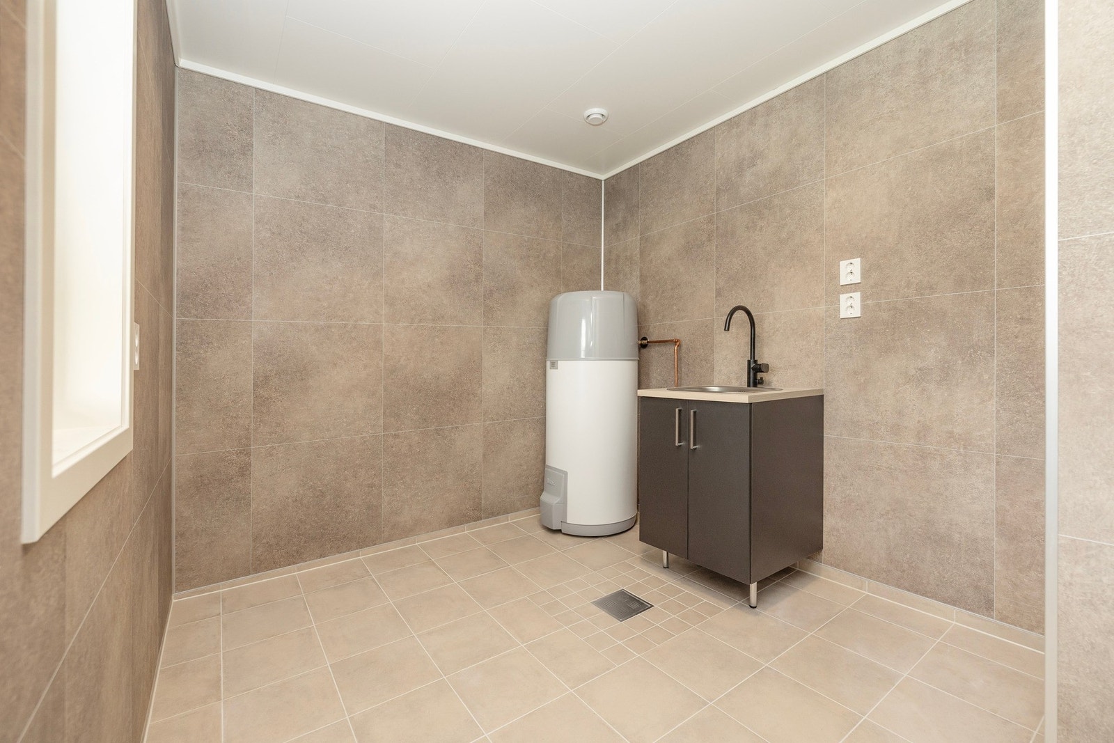 Varmtvannsbereder, samt vask med servant. Opplegg for vaskemaskin og tørketrommel. Galleribilde