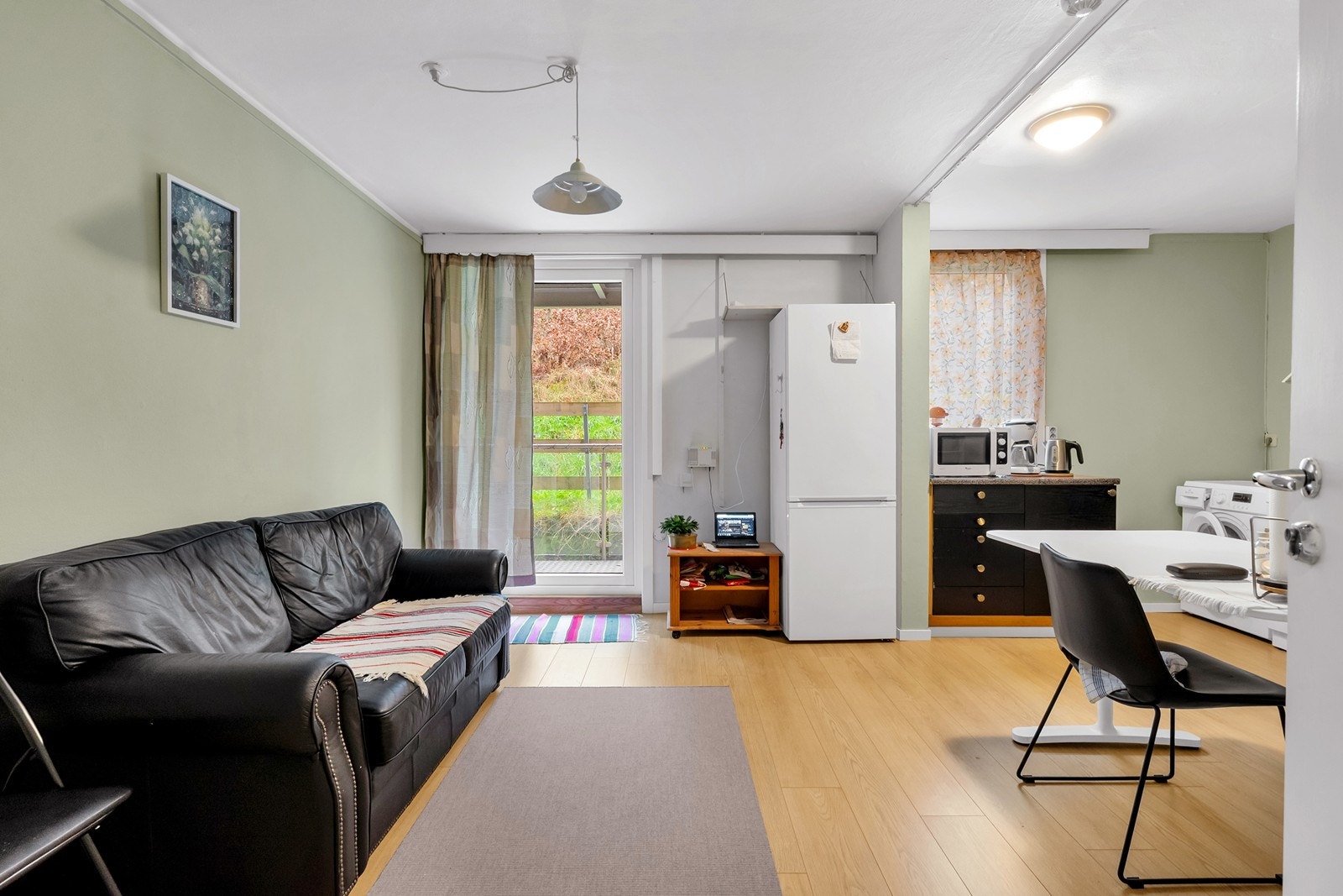 Romslig stue/kjøkken med utgang til uteplass på baksiden av bygget. Galleribilde