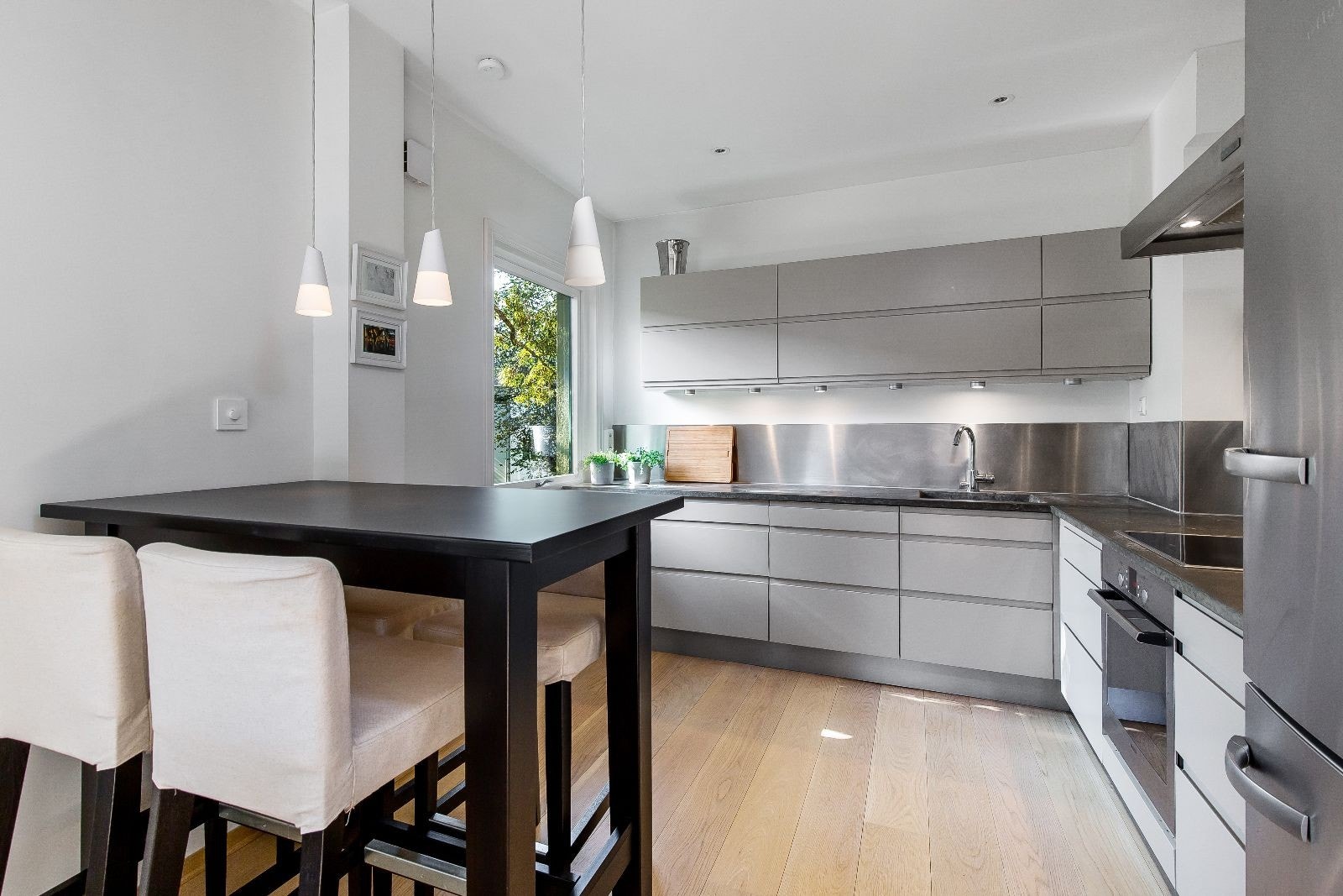 Åpen kjøkkenløsning med integrerte hvitevarer og spise øy-løsning Galleribilde