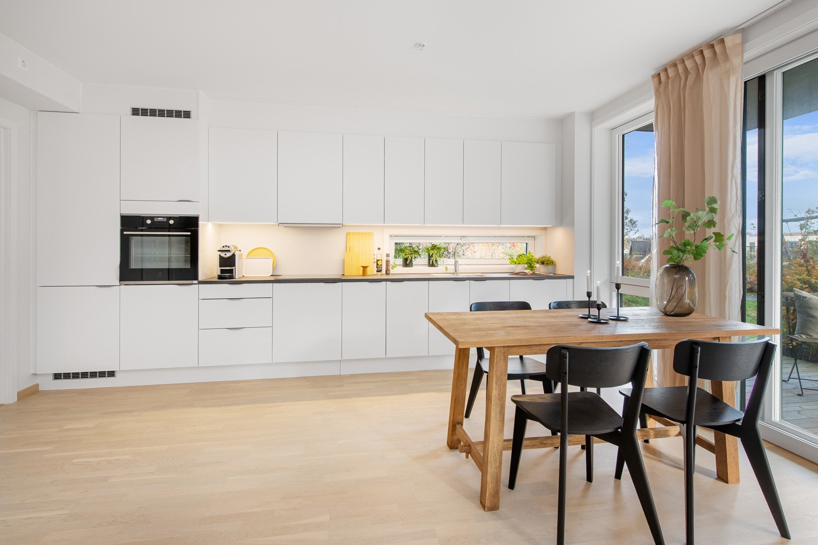 Integrerte hvitevarer, med kombi kjøl-/fryseskap, oppvaskmaskin, platetopp og ovn i høyskap Galleribilde