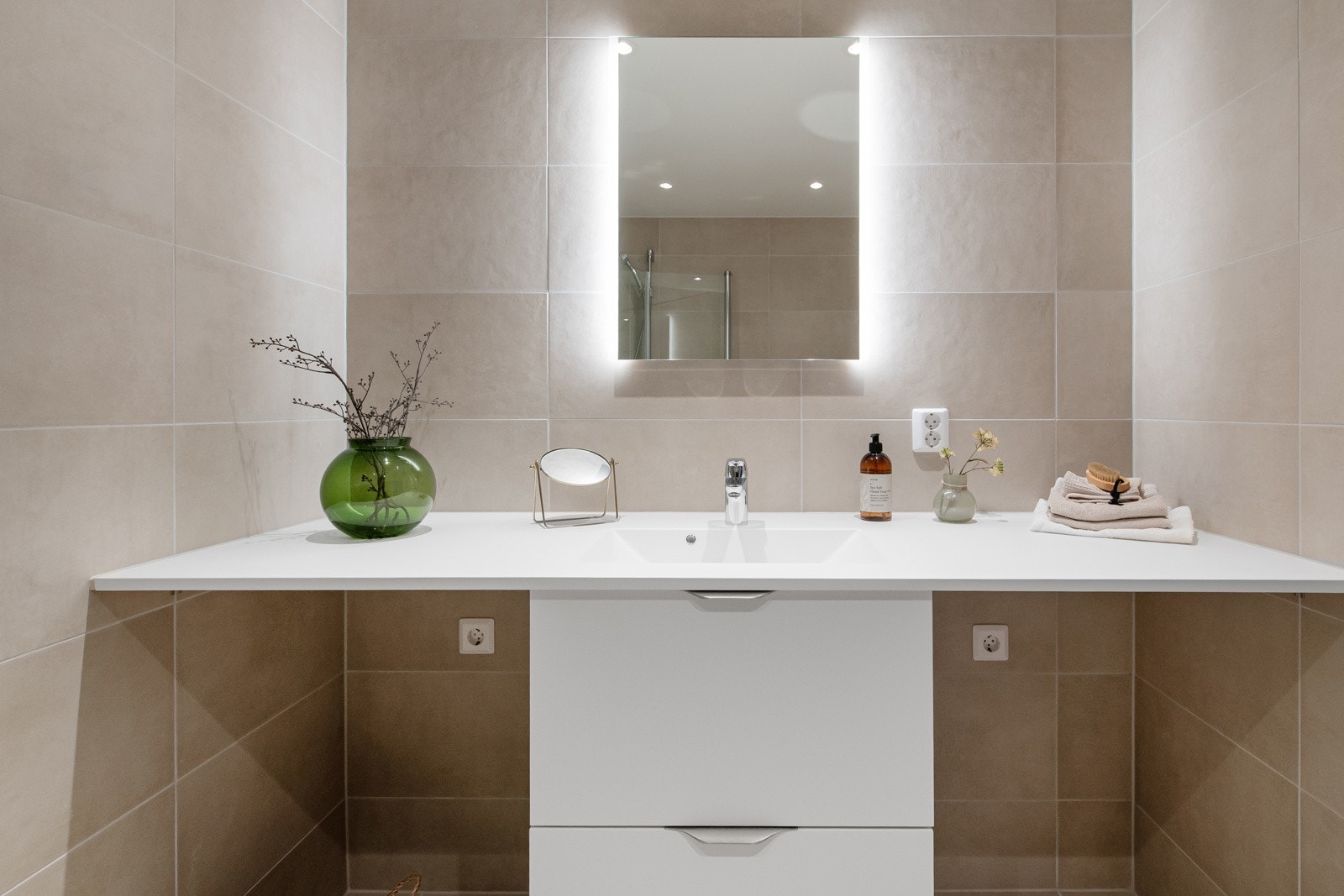 Opplegg til vaskemaskin og tørketrommel på hver side av baderomsinnredningen. God og funksjonell benkeplate med integrert servant. Galleribilde