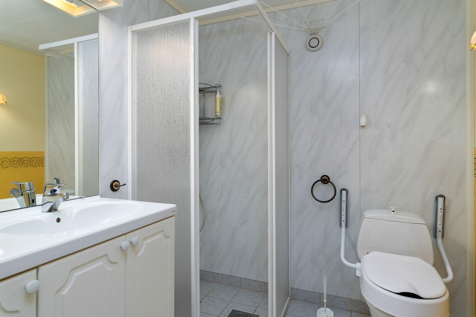 Badet i underetasjen har fliser på gulv og elektrisk gulvvarme. Rommet er innredet med servant, wc og dusjhjørne. Galleribilde