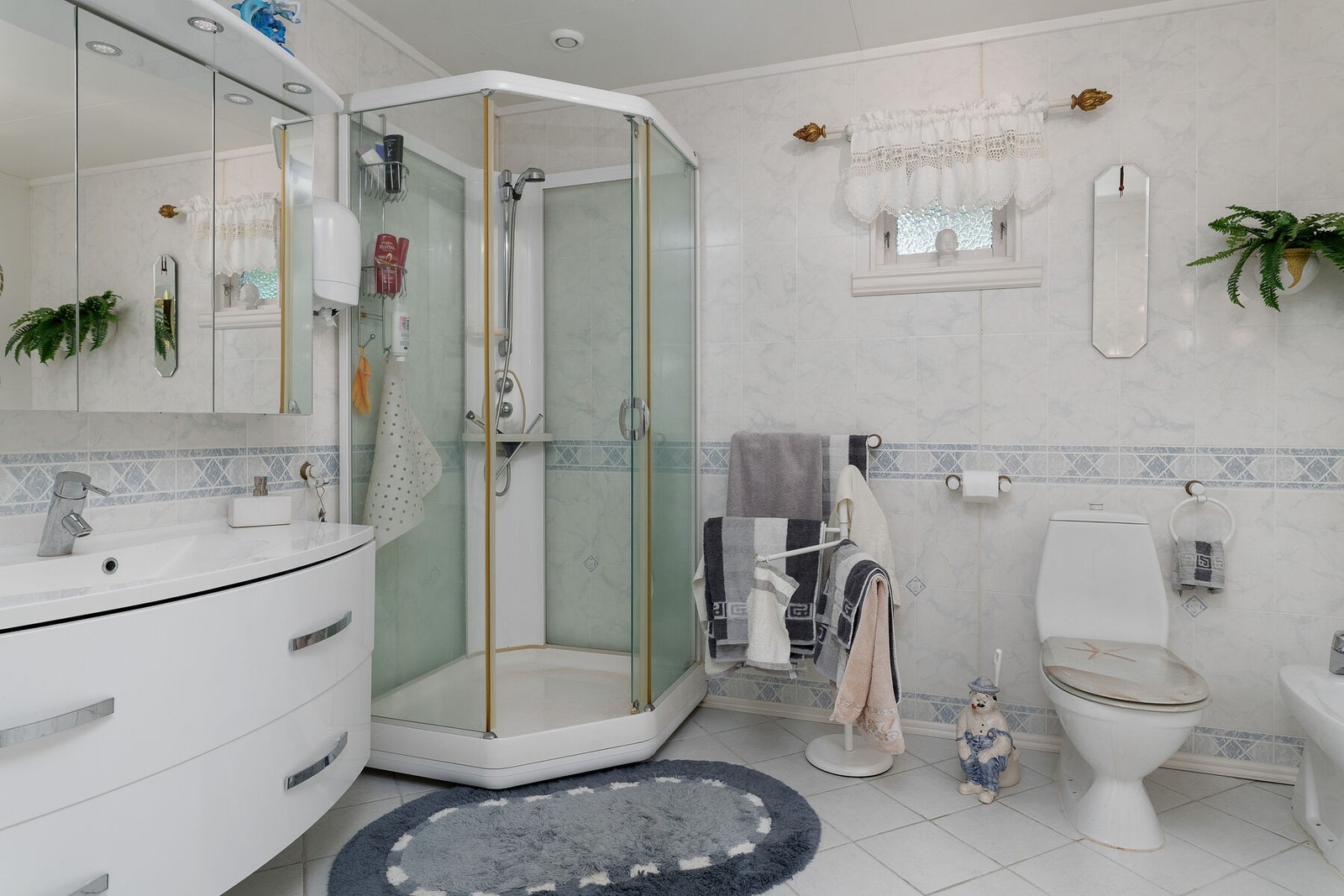 Hovedbad i 1. etasje fra byggeår, ombygget og oppusset ca. 2005. Badet har våtromsplater og malte plater på vegger, og det er flislagt gulv med elektrisk gulvvarme. Galleribilde