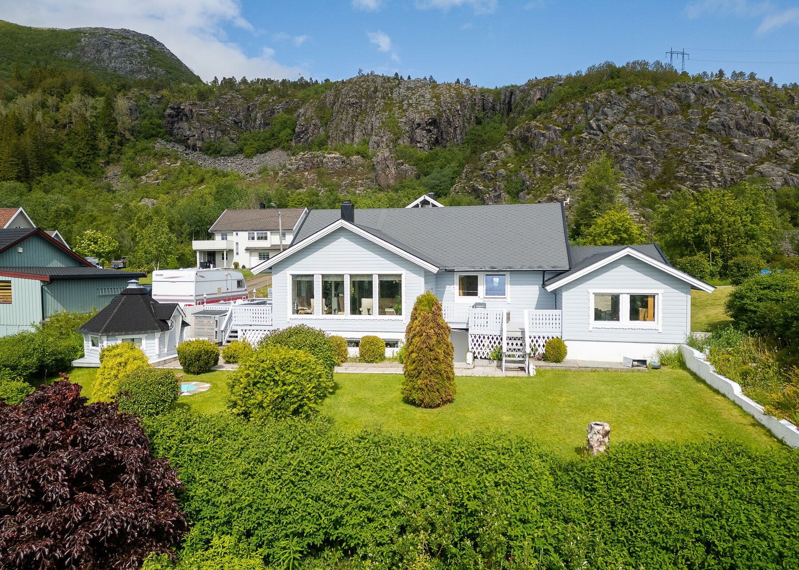 Uteområdet er flott opparbeidet med plen, busker og beplantning, samt betongheller, terrasser, flaggstang og grillhytte. Galleribilde