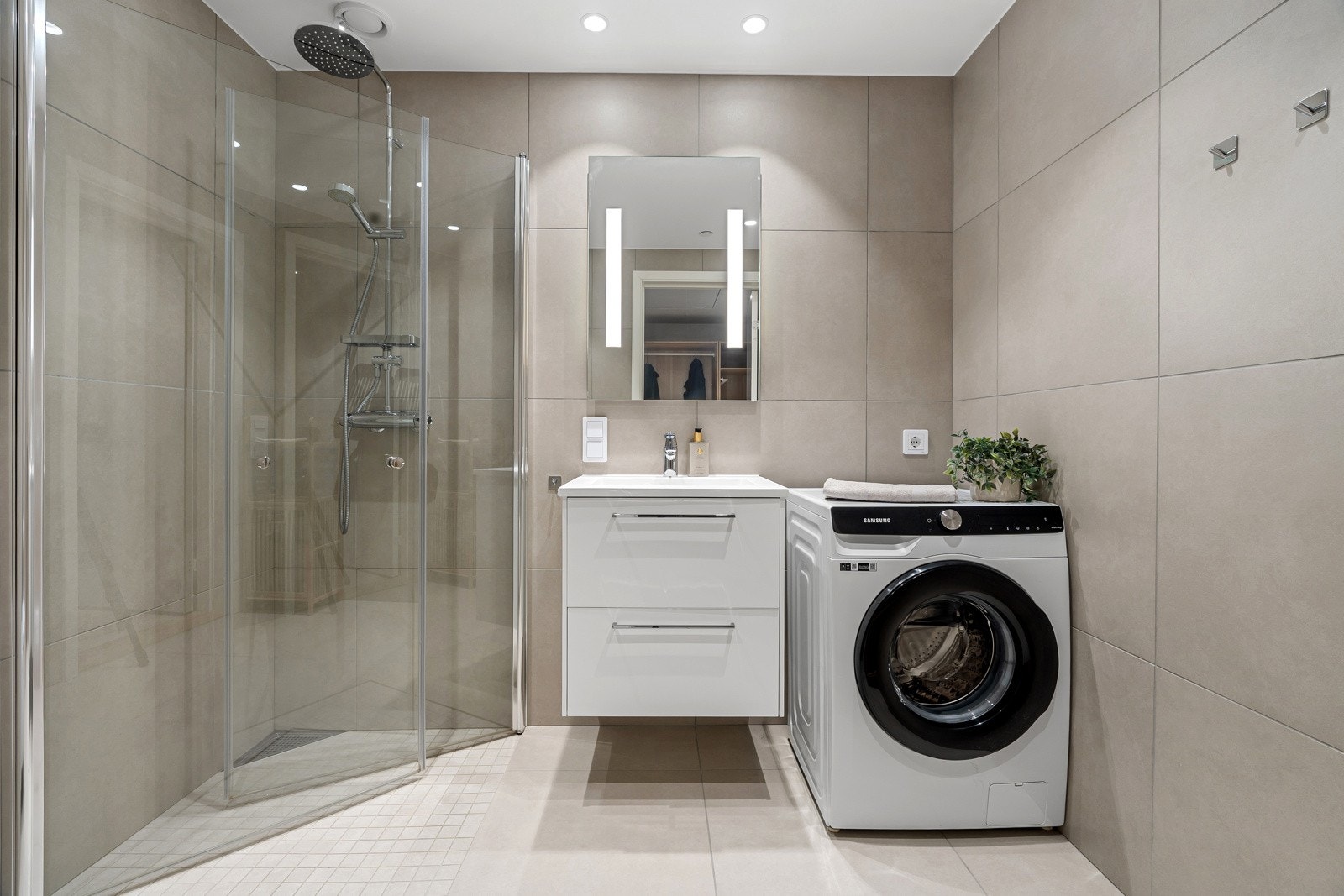 Delikat flislagt bad med 60x60 flis, dusjhjørne med innfellbare dusjvegger og opplegg for vaskemaskin.