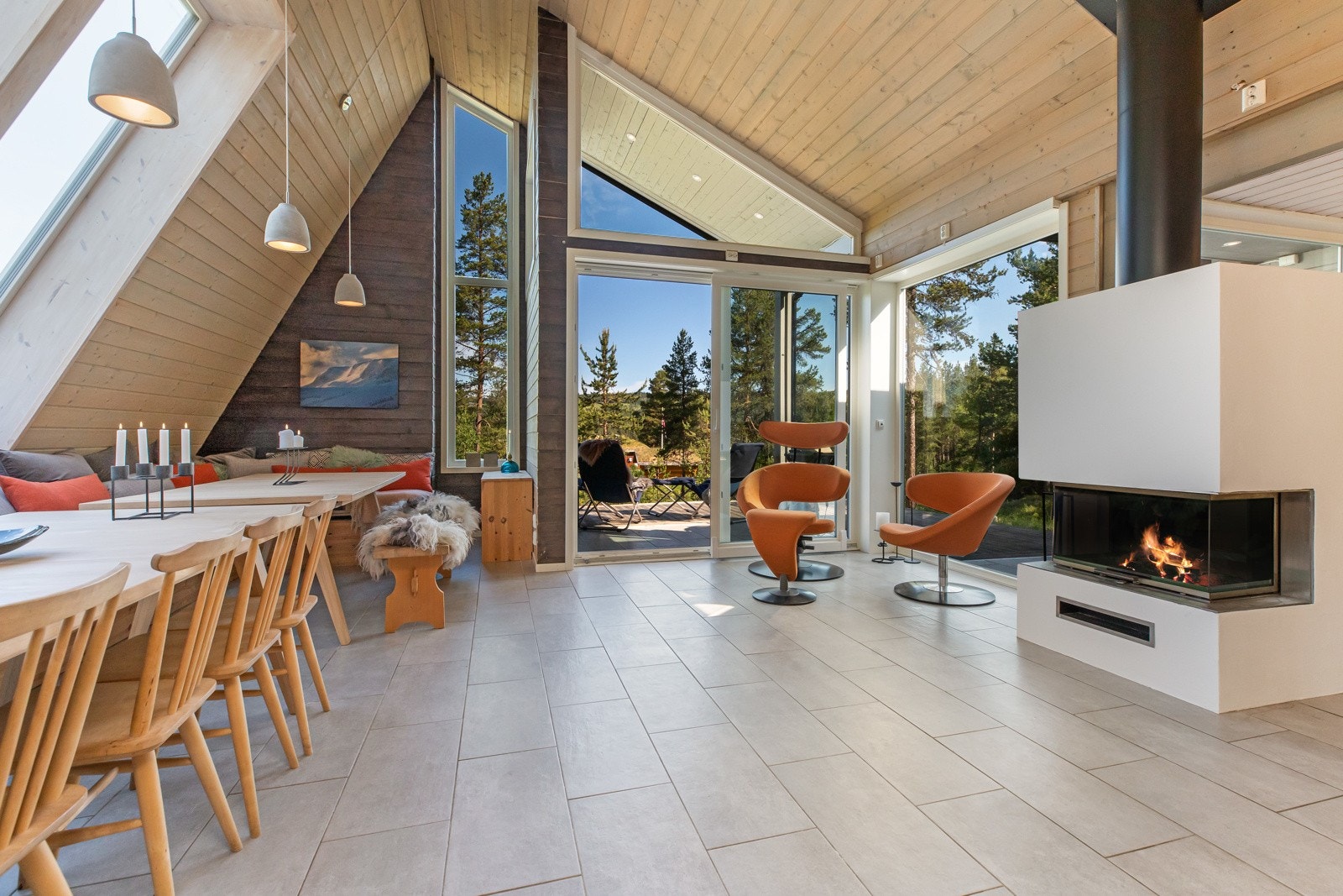 Det arkitekttegnede tilbygget har stue som fungerer som et stort allrom. Flott peis som ruver i rommet og bidrar til en hyggelig atmosfære Galleribilde