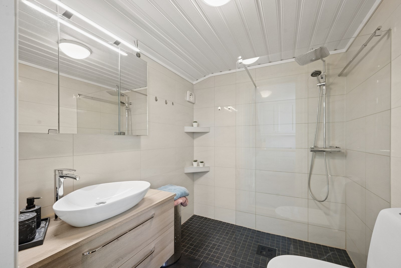 Badet ble renovert i 2019 og er pent utført med flislagte overflater og gulvvarme. Videre er det servantinnredning, dusjhjørne, speilskap og toalett. Galleribilde