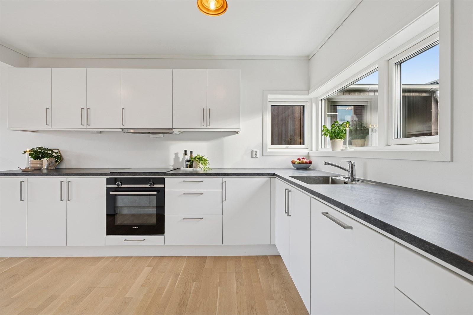 De hvite, slette frontene kombinert med den mørke laminat benkeplaten, gir et tidløst og stilrent uttrykk. Galleribilde