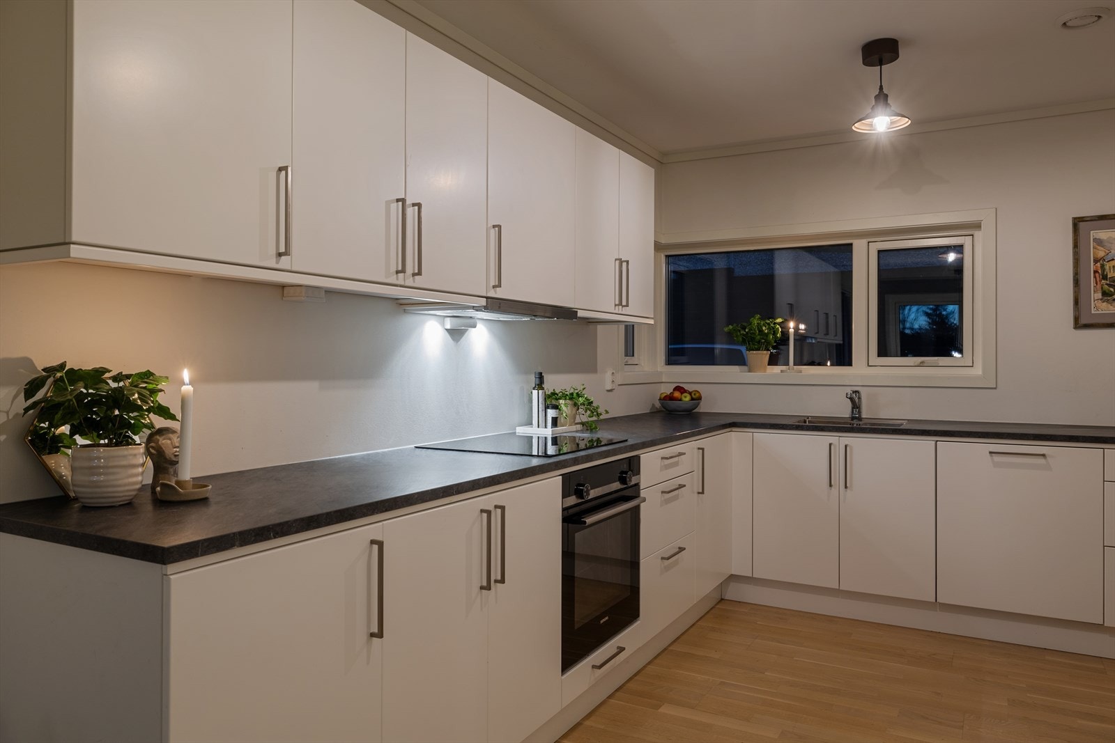 Kjøkkenet byr på rikelig skap- og benkeplass, samt integrerte hvitevarer som induksjonstopp og stekeovn. Galleribilde