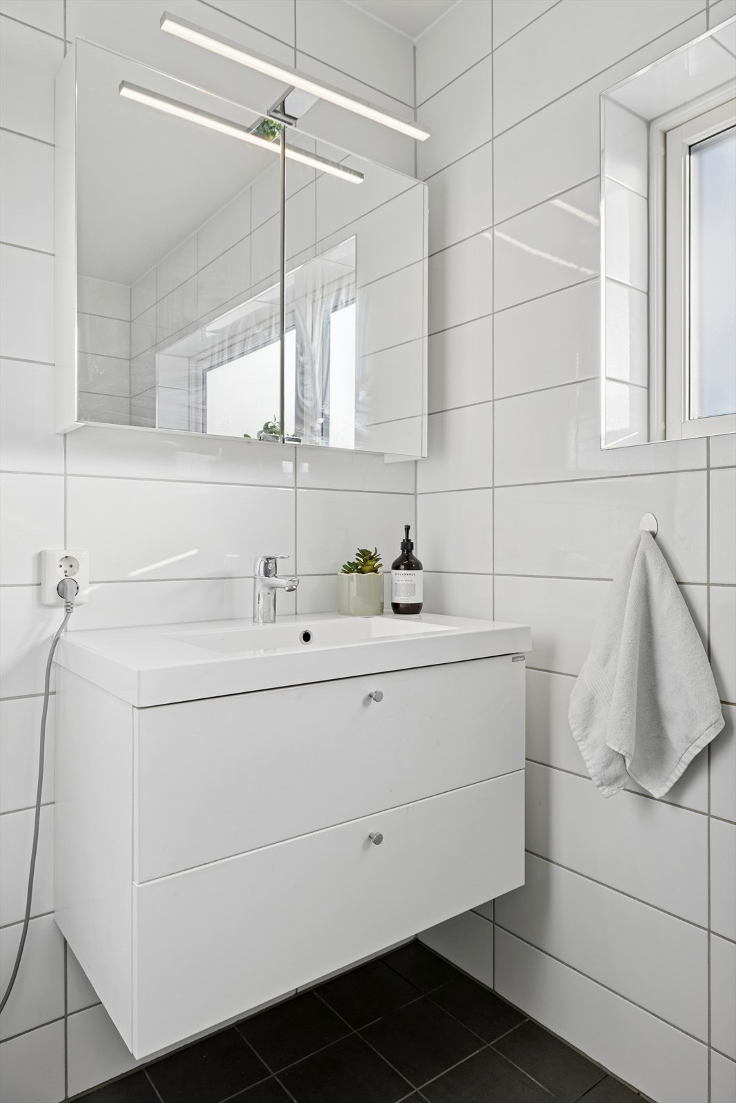 Begge badene er innredet med vegghengt toalett, nedfelt servant og dusjhjørne. Badet i 2. etasje har i tillegg opplegg for vaskemaskin. Galleribilde