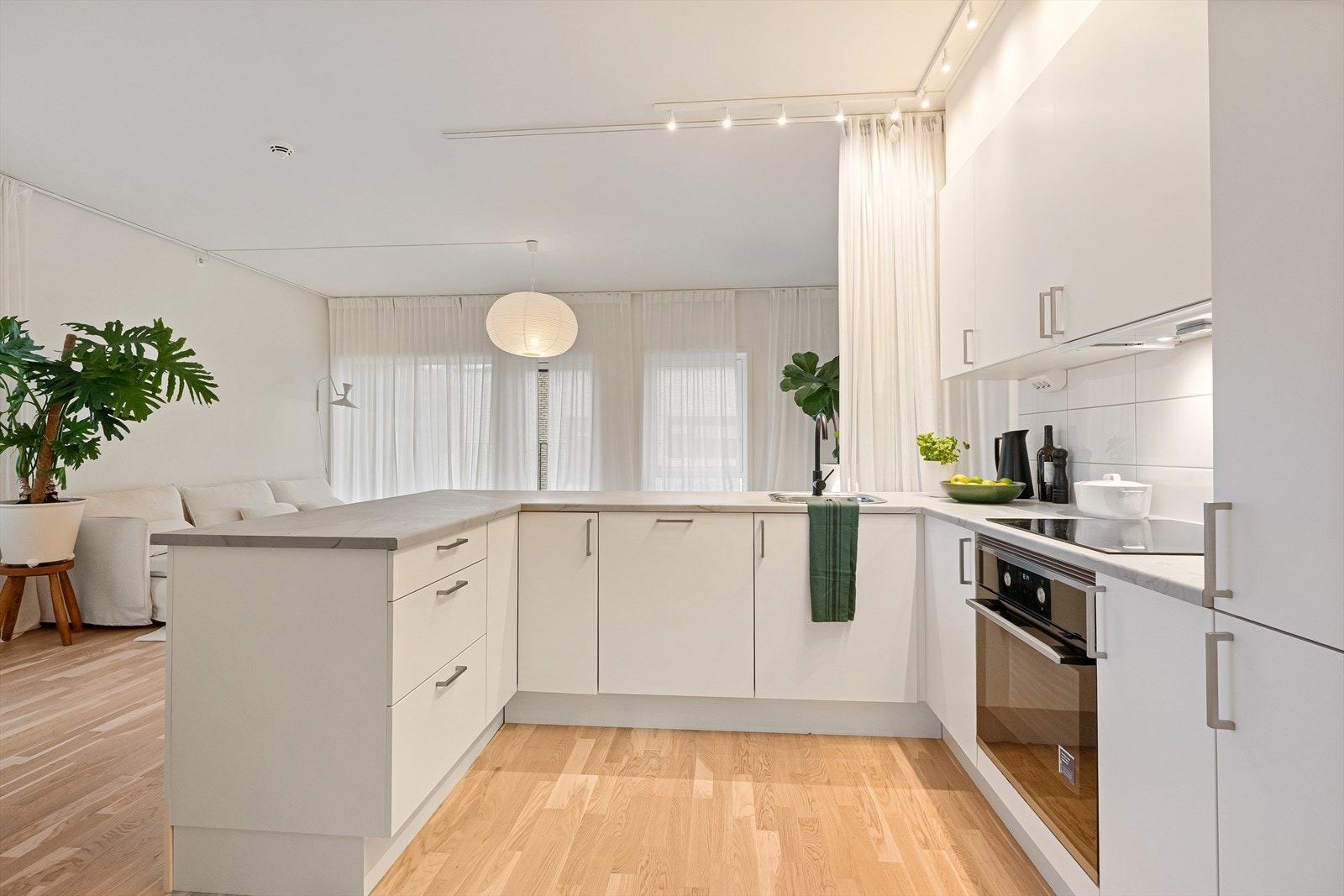 Lys og moderne kjøkkenløsning med åpen planløsning mot stuen. Eget vaskerom/grovkjøkken i eget rom ved kjøkken Galleribilde