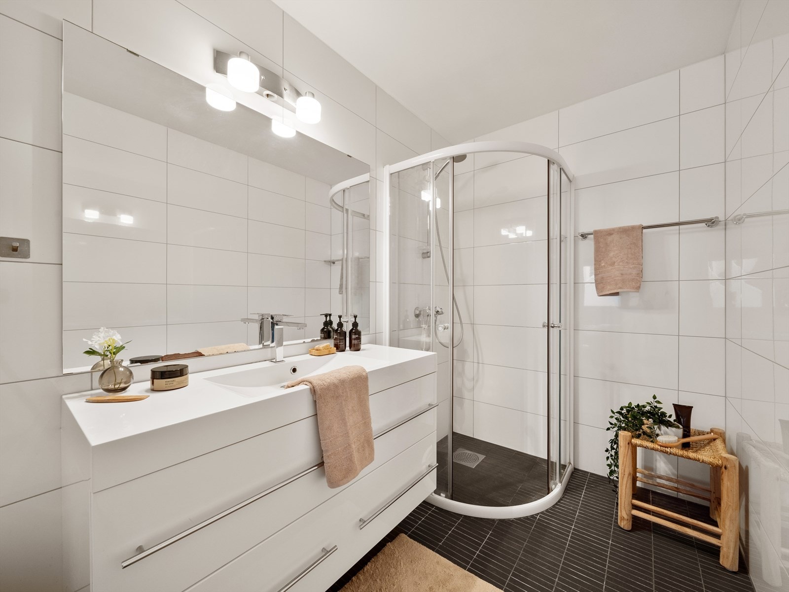 Badet er innredet med dusjvegg, servant med møbler og toalett Galleribilde