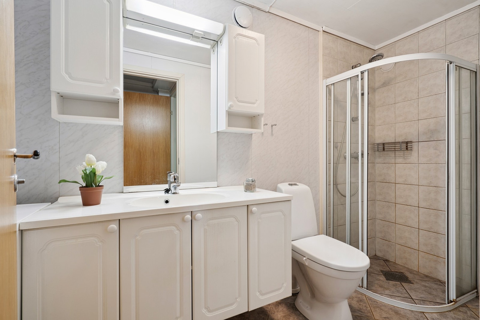 Baderom med delvis flislagte vegger og helfliset gulv med behagelig gulvvarme. Galleribilde