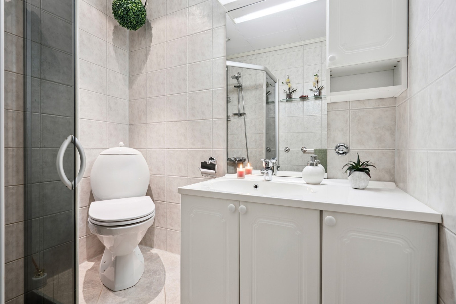 Gode oppbevaringsløsninger i skap, samt praktisk hjørnedusj med skyvedører. Galleribilde