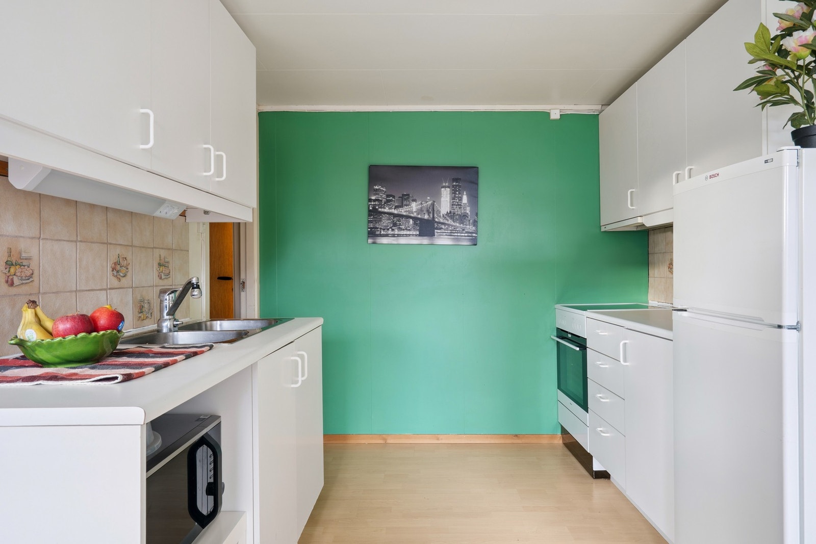 Praktisk kjøkken i sokkeletasje med mye skap- og benkeplass. Galleribilde