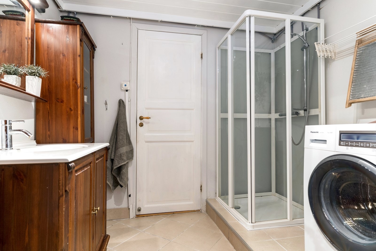 Baderom av god størrelse innredet med servantskap med høyskap, dusj og toalett. Galleribilde