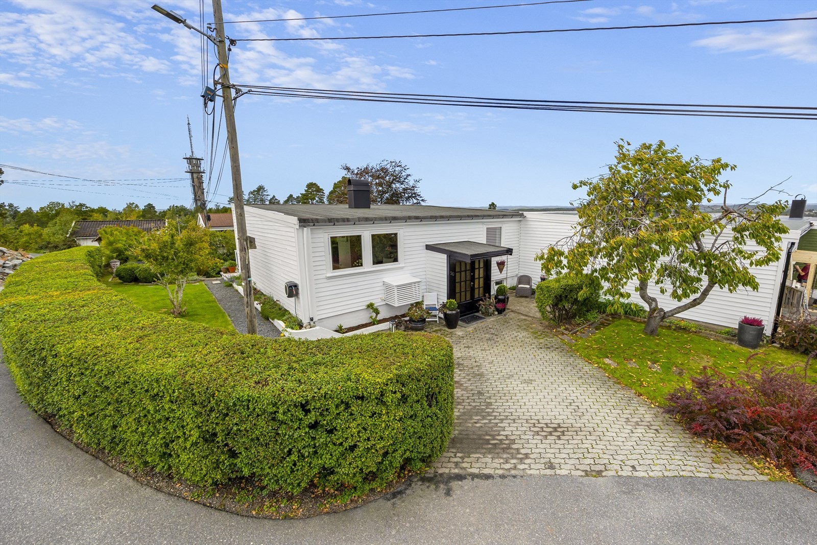 Fin beplantning med prydbusker, bed, gruset gangvei og hellelagte plattinger. Hellelagt innkjørsel og gårdstun med god parkering. Galleribilde