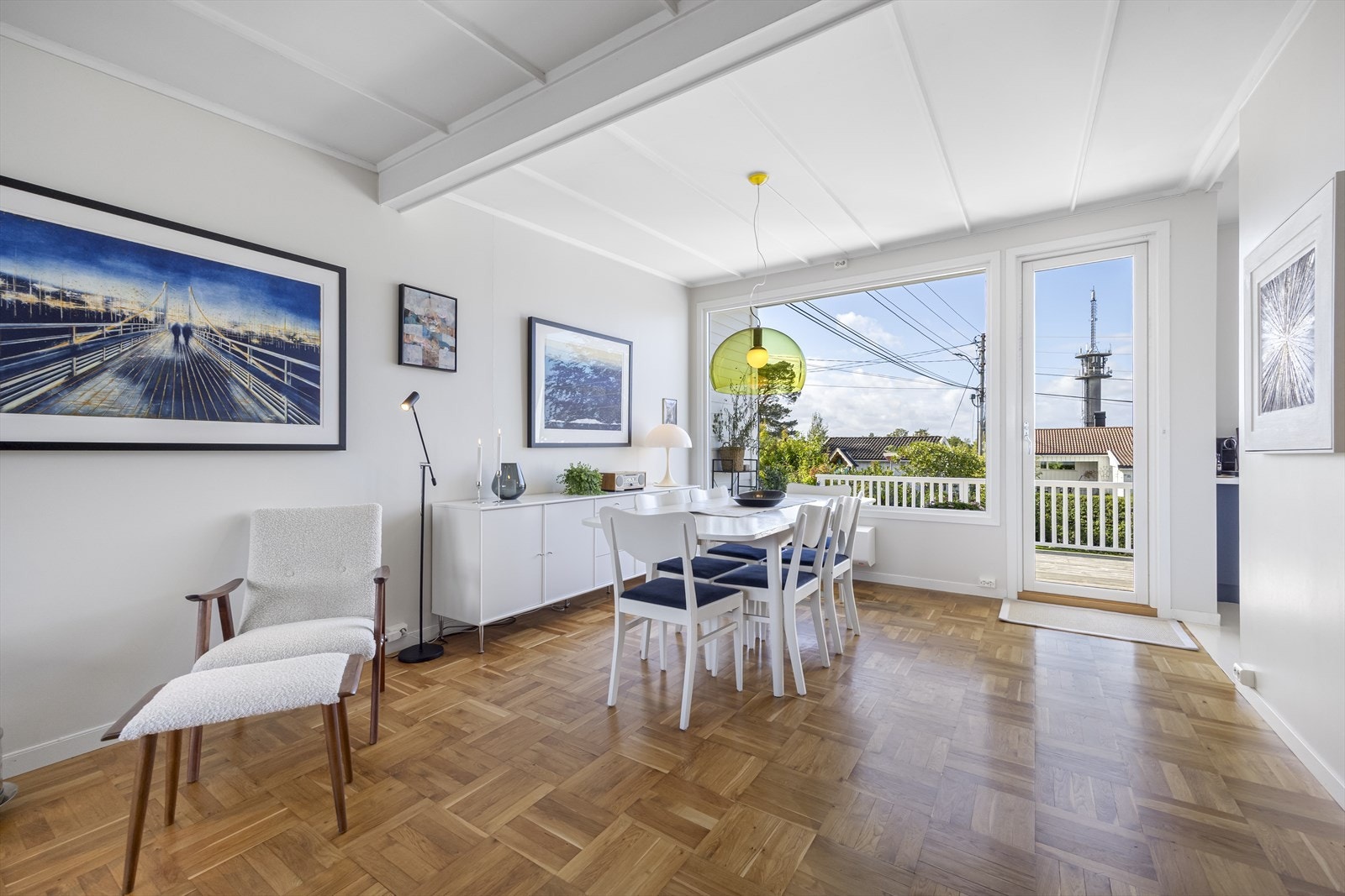 Stue / spisestue med klassisk stavparkett, store vindusflater med mye naturlig lys og direkte utgang til stor, vestvendt terrasse. Galleribilde