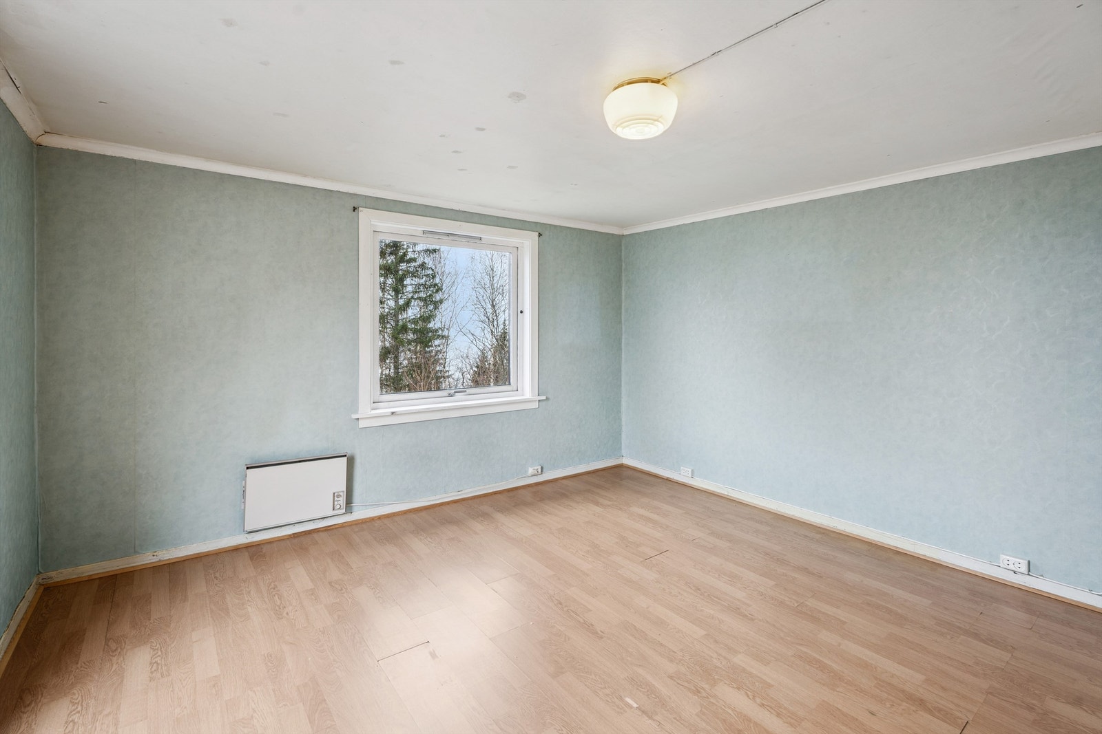 Et av soverommene i andre etasje, med laminatgulv og tapetserte vegger. Galleribilde