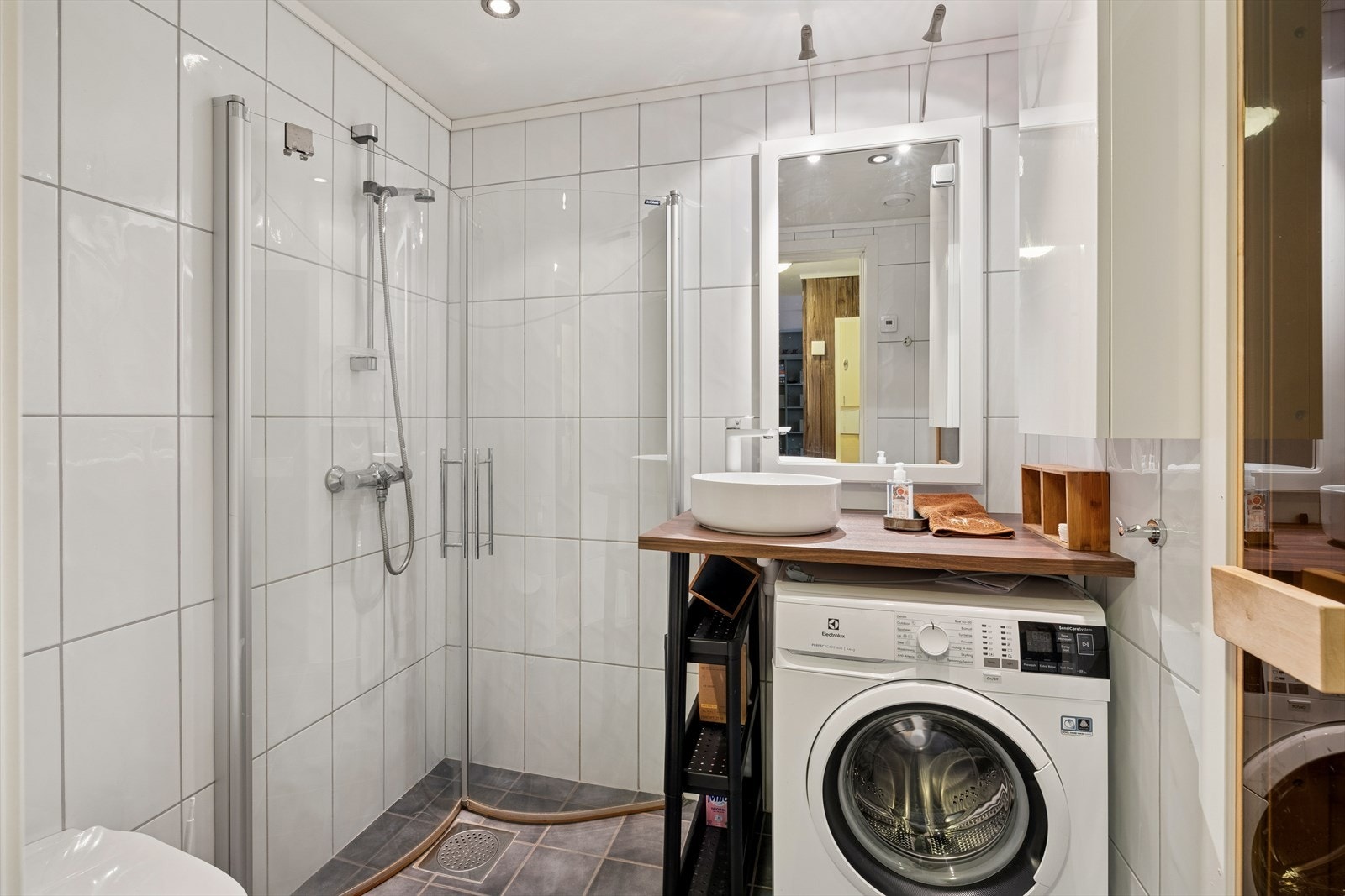 Badet er delikat innredet med dusjhjørne, vegghengt toalett, servant og praktisk oppbevaringsskap | Det er også montert inn vaskemaskin! Galleribilde