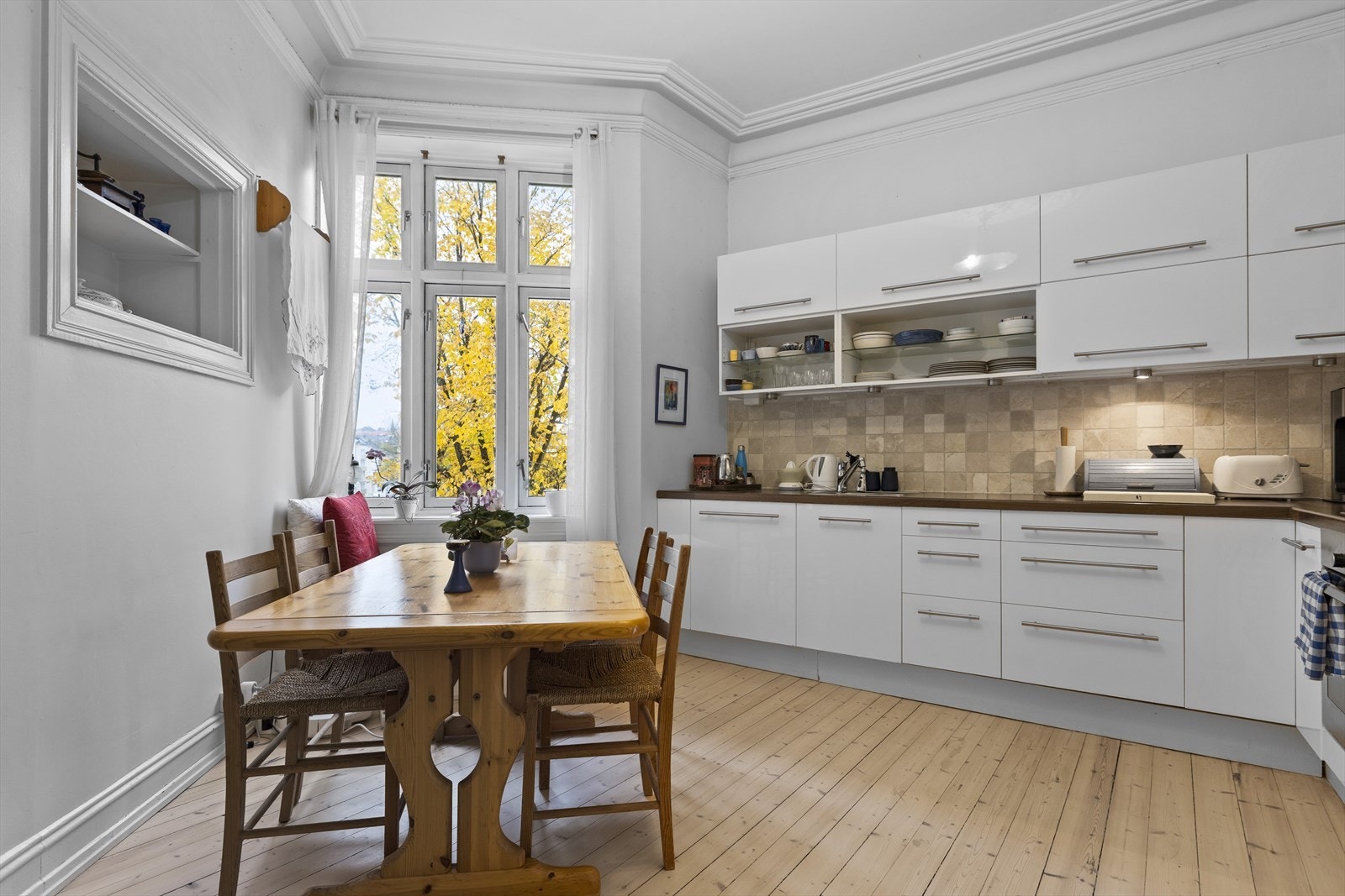 Stort kjøkken med peis, hyggelig spiseplass og fin rosett i taket. Galleribilde