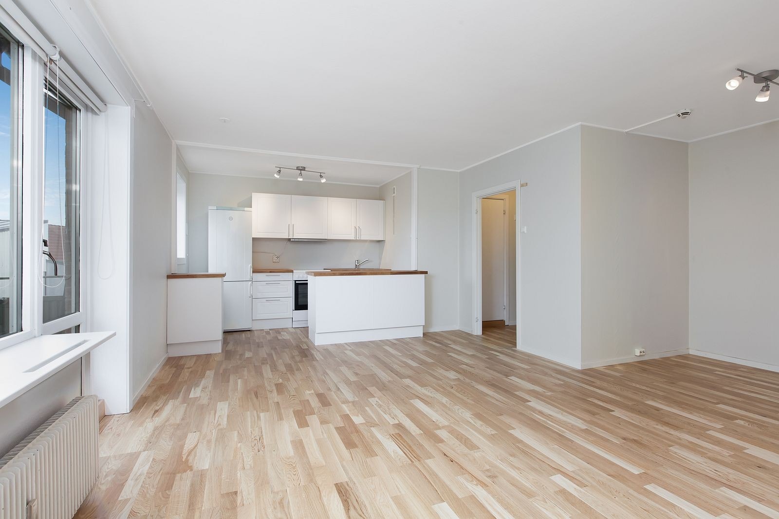 Romslig lys stue med åpen kjøkkenløsning. Galleribilde