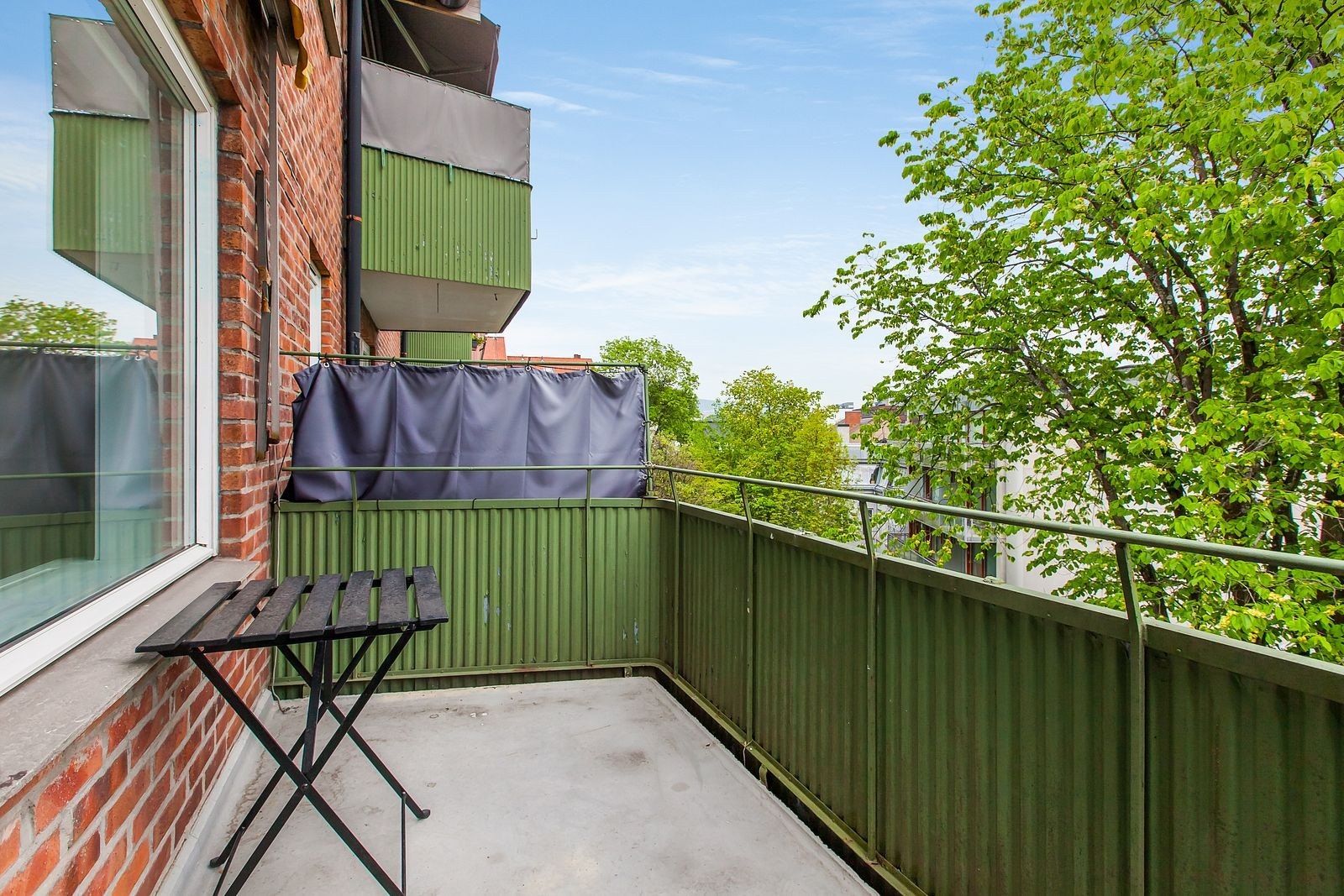 Solrik balkong som vender mot koselig grønn bakgård Galleribilde