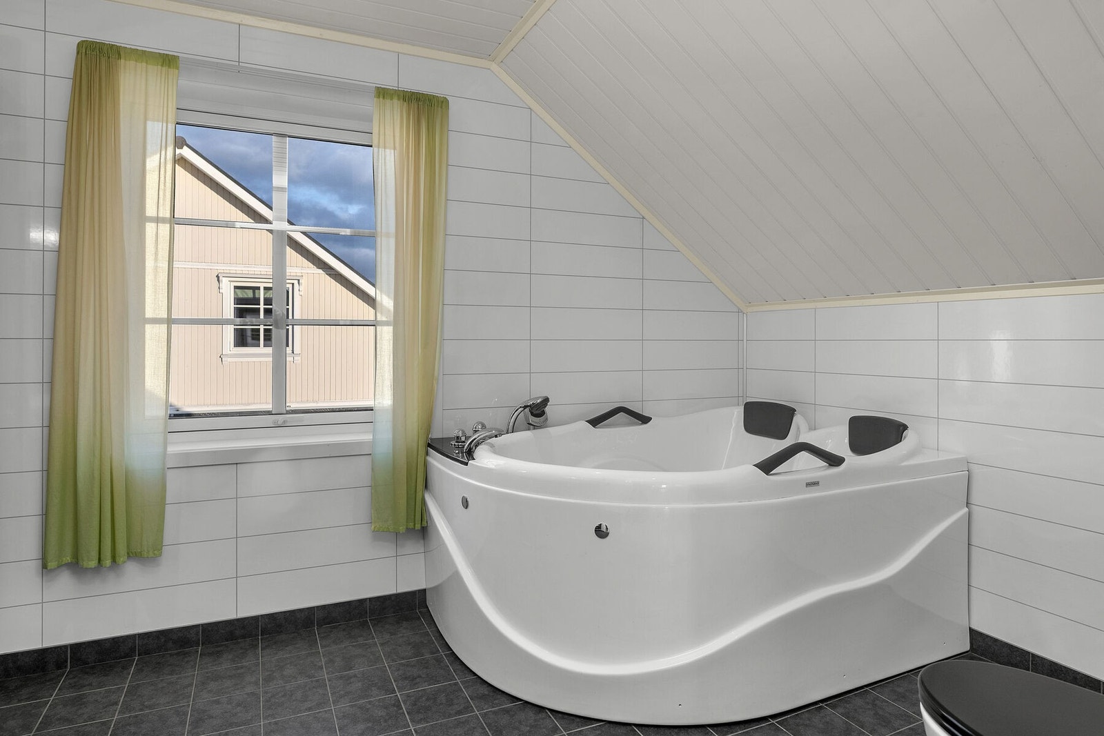 Badet er utstyrt med baderomsinnredning med nedfelt servant, veggmontert toalett og boblehjørnekar. Galleribilde