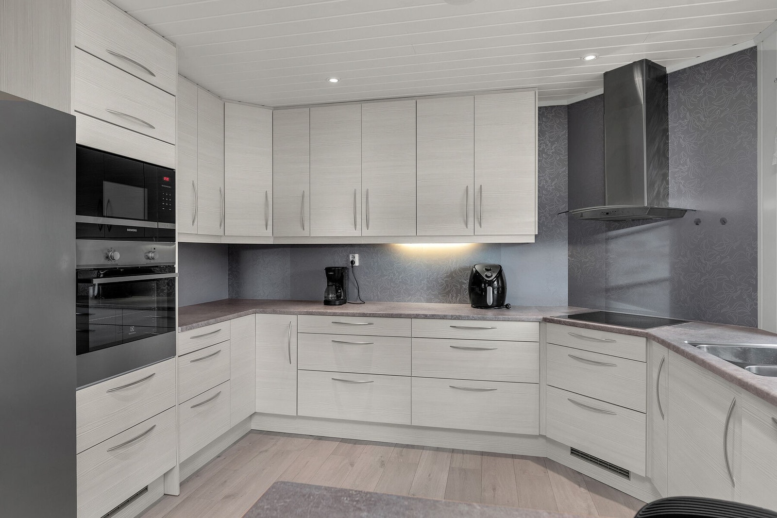 Et klassisk og pent kjøkken med integrerte hvitevarer. Galleribilde