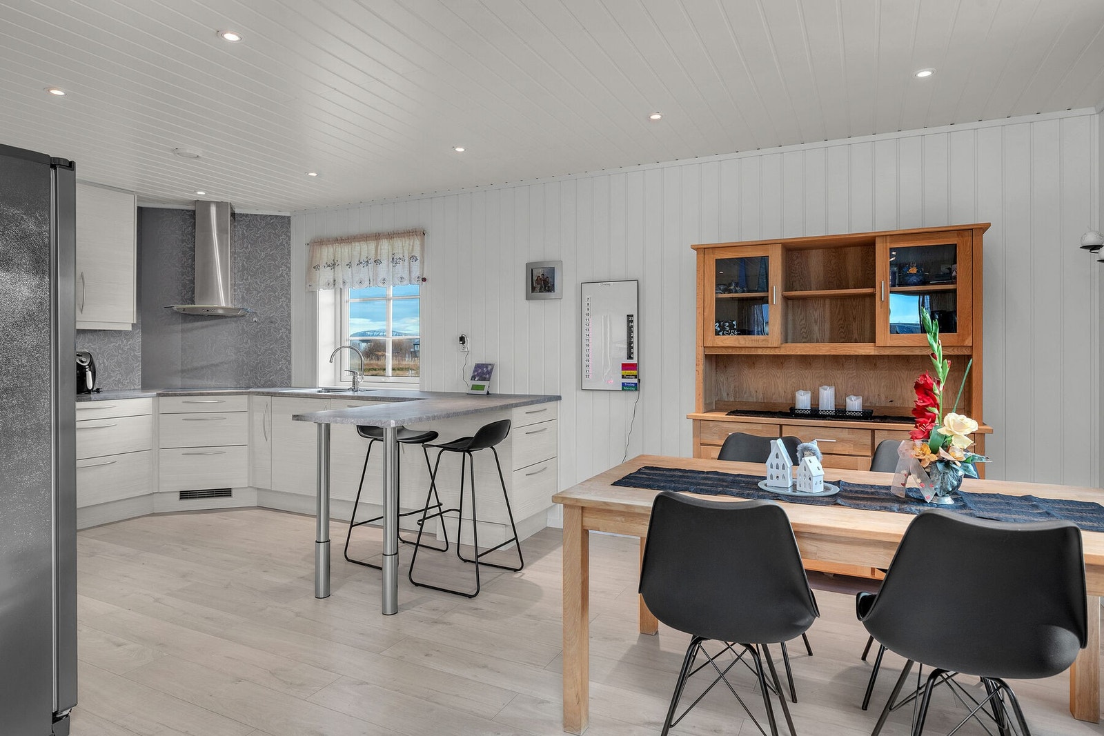 Stue og kjøkken i åpen løsning med sitteplasser - en sosial og funksjonell løsning, som også gjør romfølelsen luftig. Galleribilde