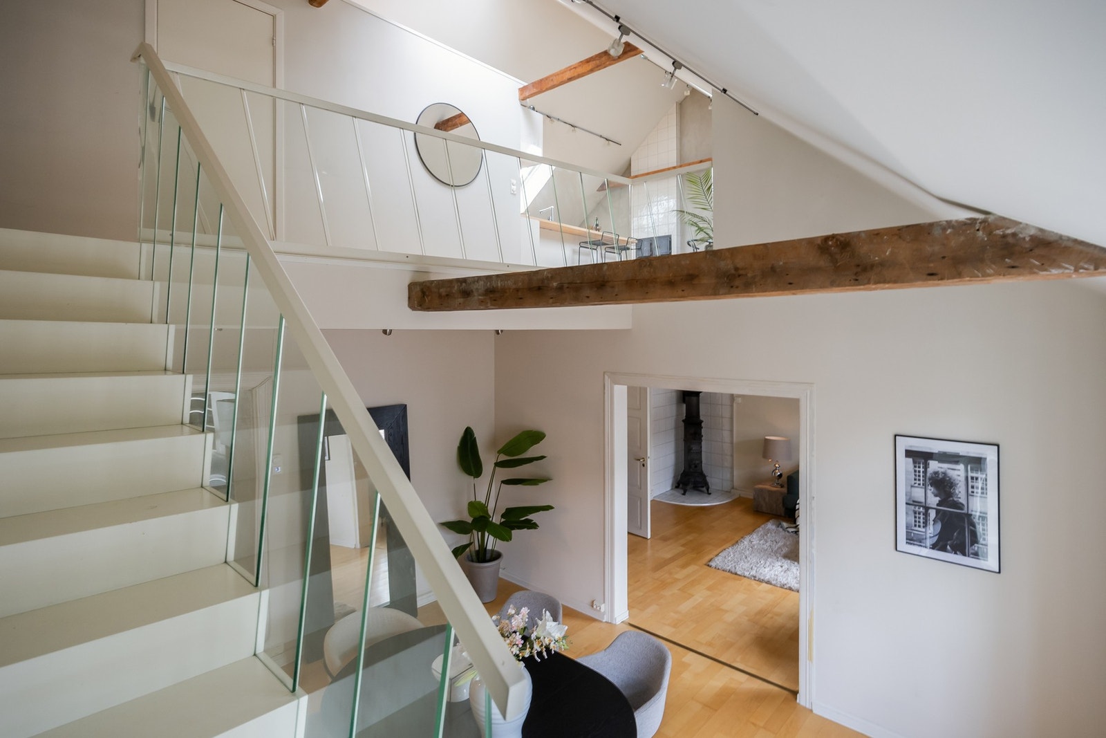 Den åpne himlingen og trapp med glassrekkverk gir en behagelig strøm av lys gjennom boligen. Galleribilde