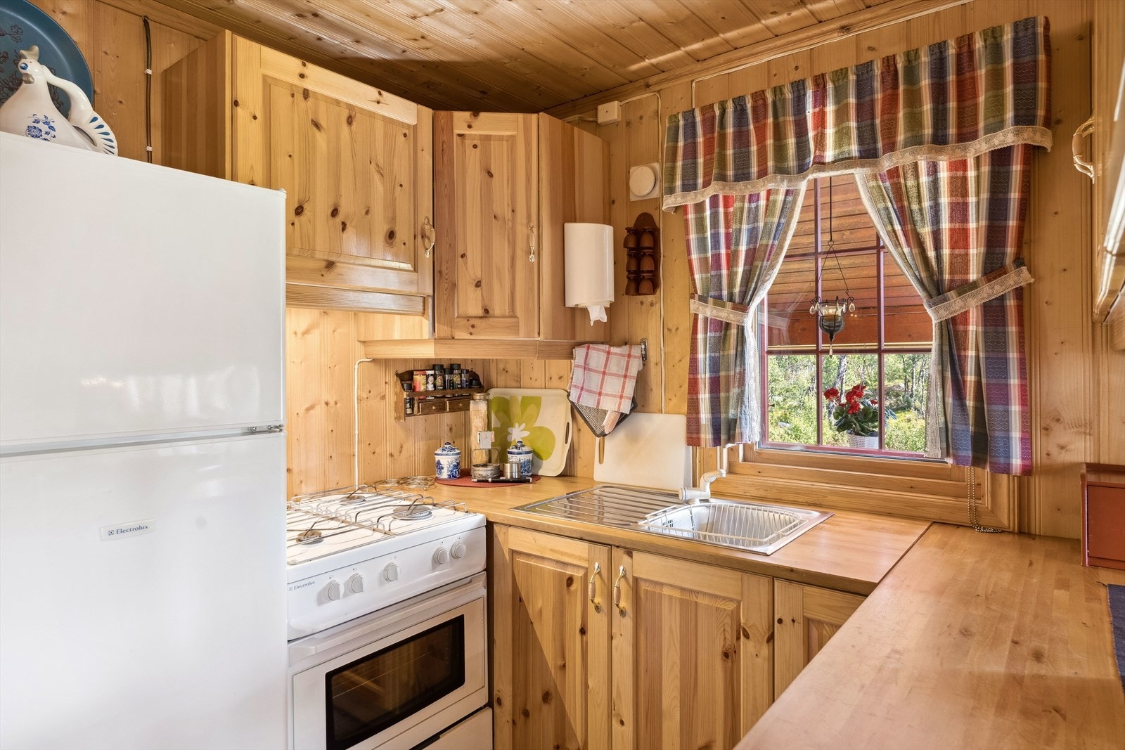 Tradisjonelt heltre kjøkken med innredning i malte folierte plater og profilerte fronter. Galleribilde