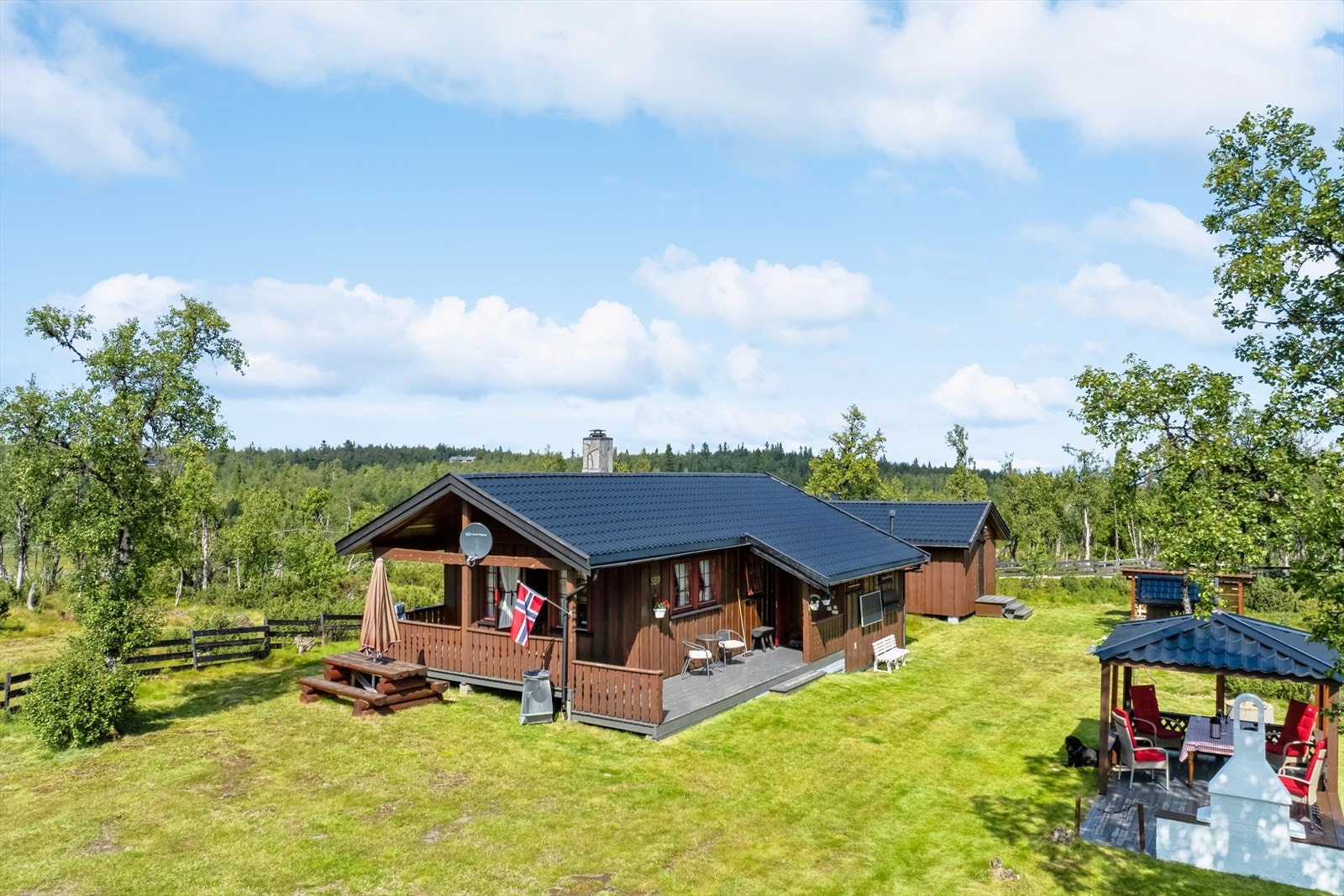 Tomten er pent opparbeidet med mange fine uteplasser. Her kan solen nyten uten på terrassen eller på den trivelige paviljongen. Galleribilde
