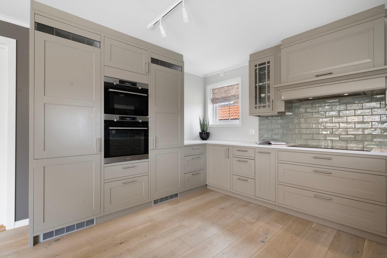 Integrert fryseskap, kjøleskap, oppvaskmaskin, to stekeovner og induksjonstopp. Galleribilde