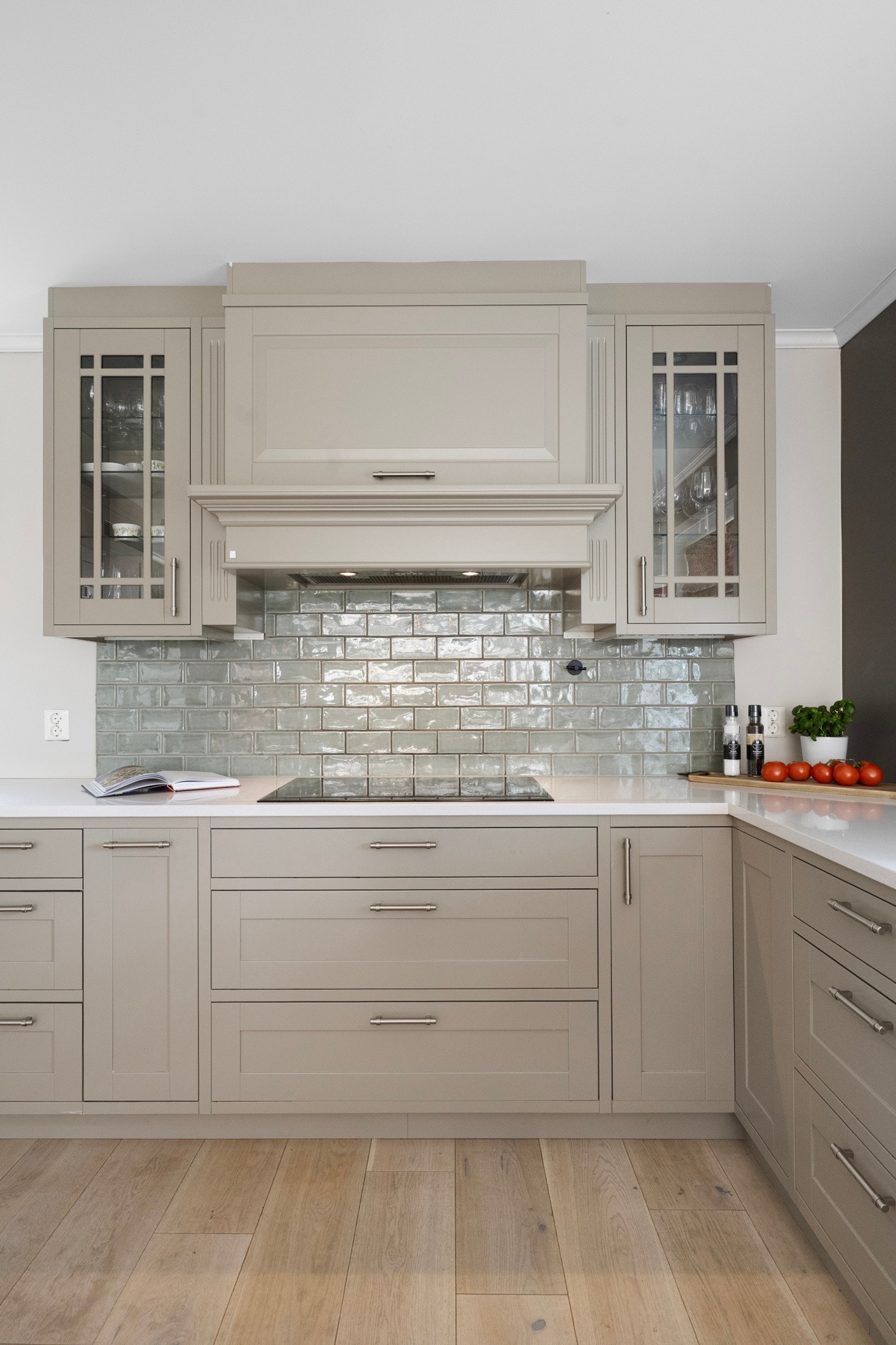 Fliser på benkerygg over koketopp. Kjøkkenventilator med avtrekk ut. Galleribilde