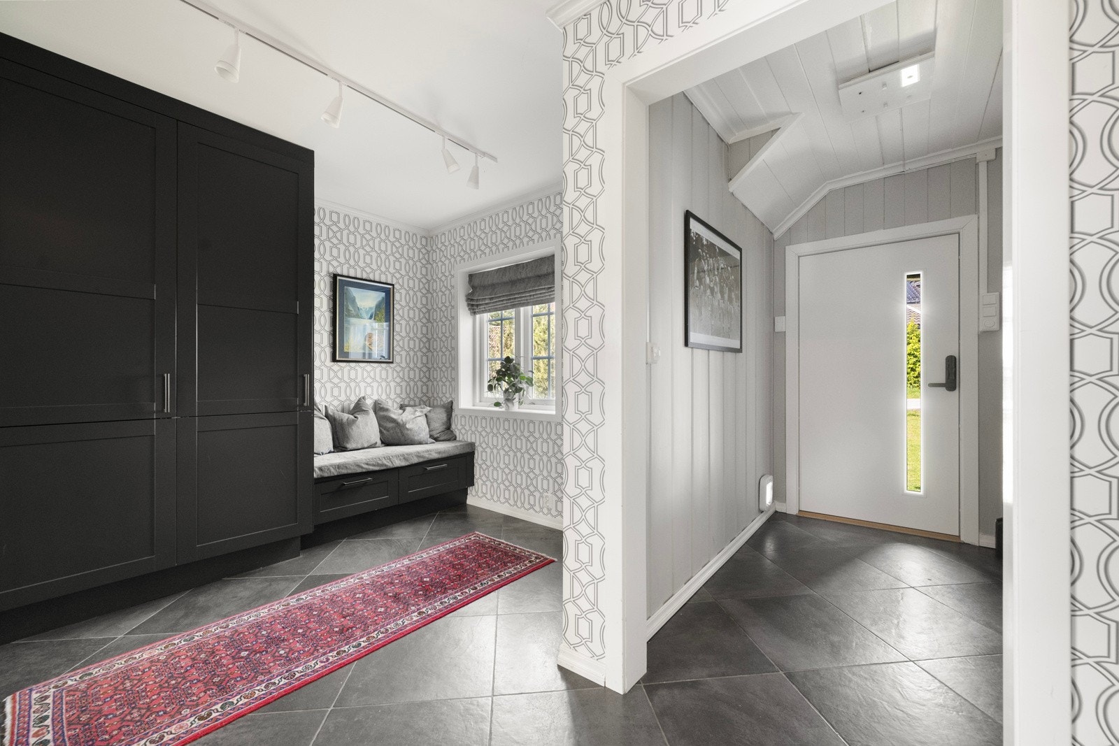 Første etasje ønsker velkommen inn til en entré som glir over i en romslig hall. Galleribilde