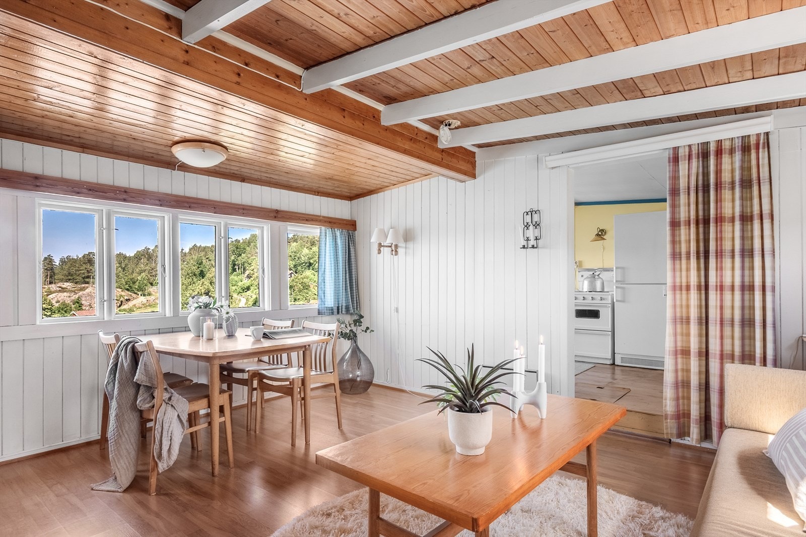 Videre fra kjøkkenet er en innbydende stue - hyttas midtpunkt med fantastisk fjordutsikt som strekker seg langt inn i rommet. Galleribilde