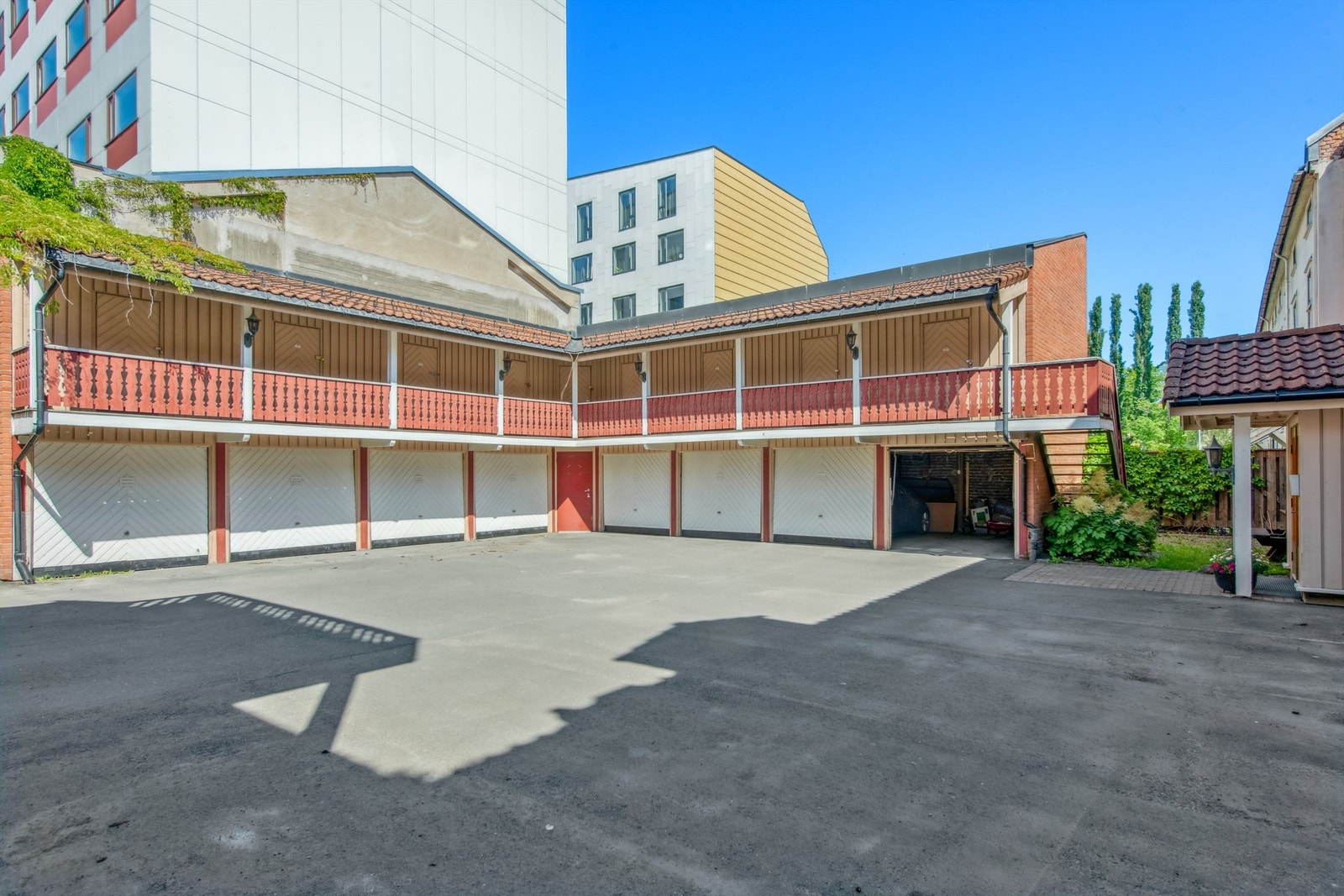 Innbydende gårdsrom med boder og garasjer gir praktiske lagringsmuligheter for beboerne. Galleribilde