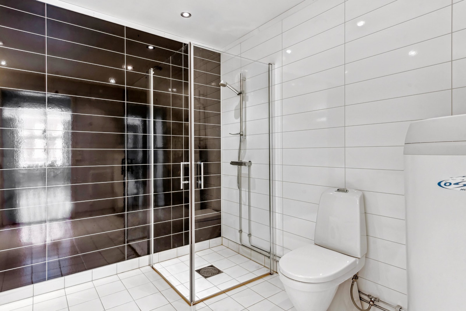 Lyst og moderne bad med stilren dusjløsning, perfekt for hverdagskomfort. Elegant design med tidløse fliser som gir et tidløst preg. Galleribilde