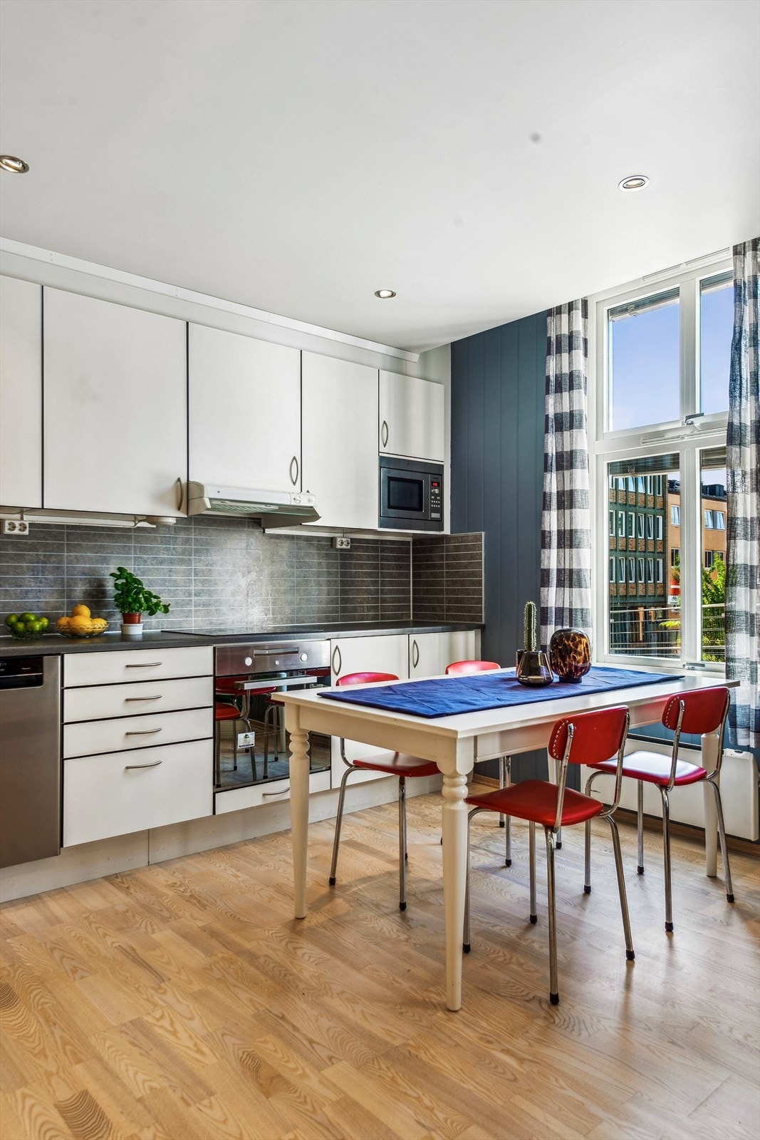 Moderne kjøkken med mye naturlig lys, stilrene overflater og romslig spiseplass. Perfekt for sosiale sammenkomster og hverdagsliv. Galleribilde