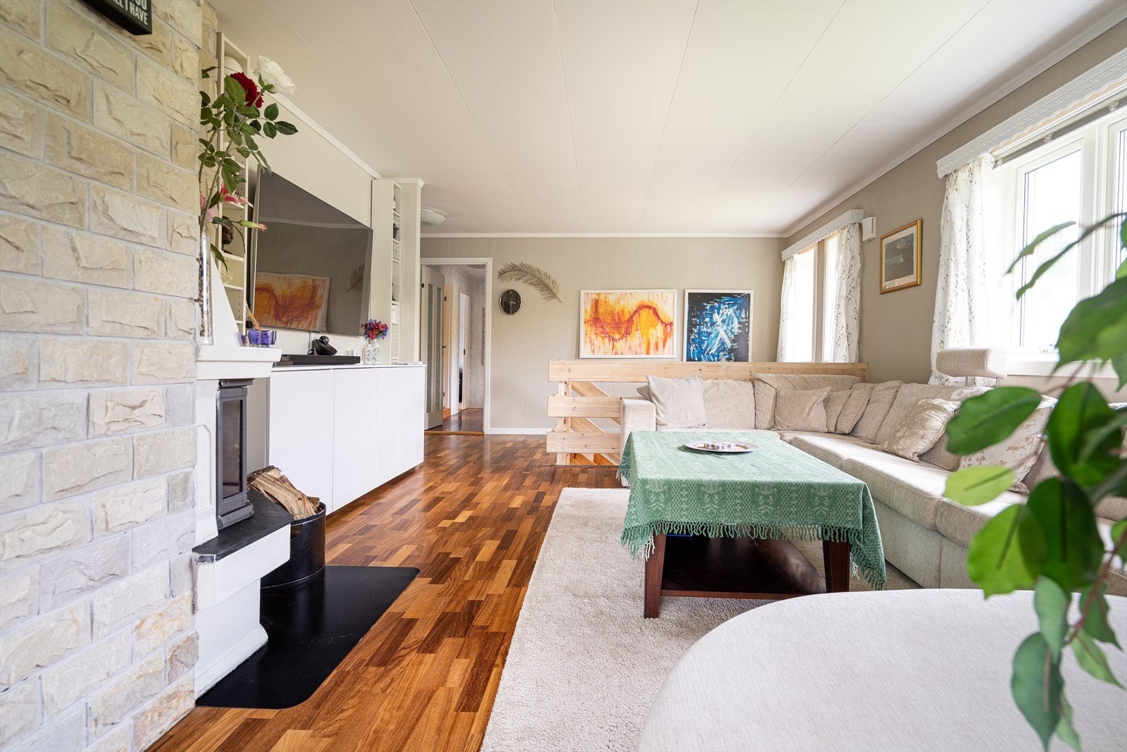 Store vindusflater i stuen på hele tre yttervegger, gir rikelig med gjennomgående, naturlig lys. Galleribilde